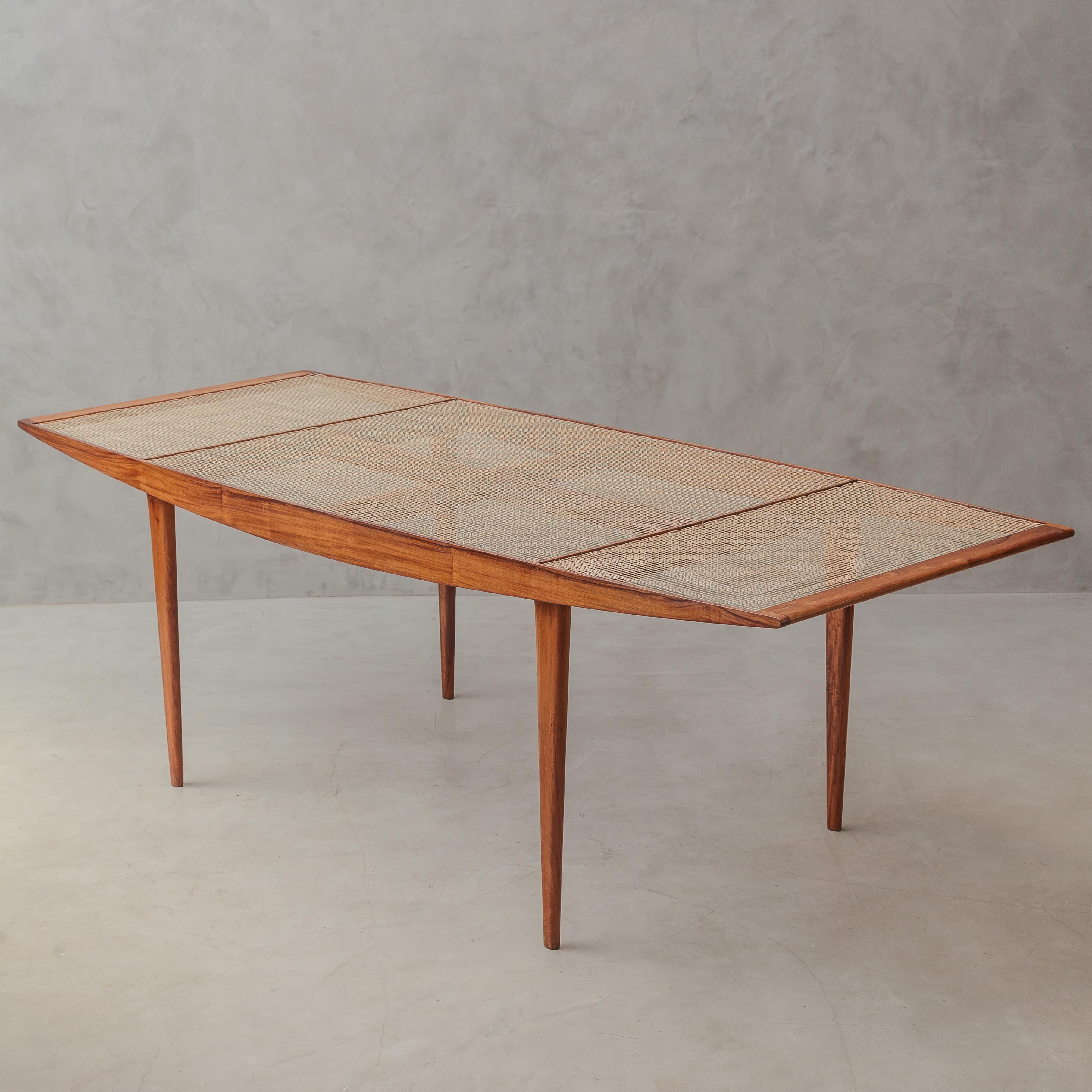 Elegante e raro tavolo da pranzo disegnato da Carlo Hauner e Martin Eisler per Forma negli anni '50, un esempio lampante di design modernista brasiliano. Realizzato in legno massiccio di caviuna con venature calde ed espressive, il tavolo presenta