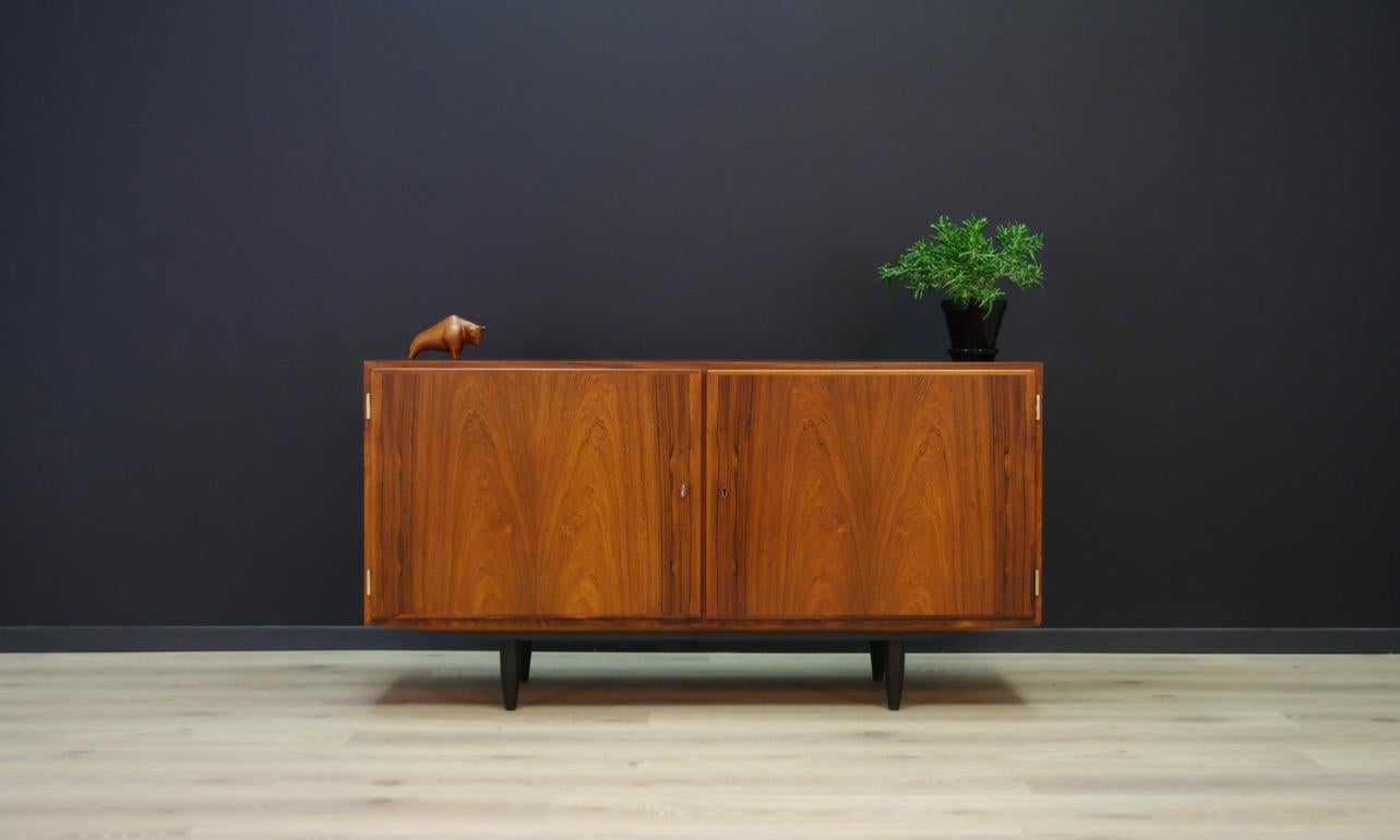 Classic cabinet from the 1960s-1970s, Minimalist form - Scandinavian design. The design by Carlo Jensen produced at Hundevad & Co. The surface is veneered with a rosewood. A spacious interior with two shelves and three drawers. The key in the set.
