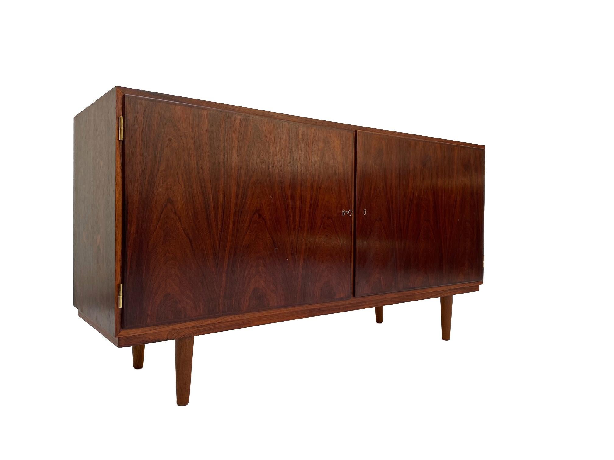 Designed by Carlo Jensen for Poul Hundevad, this rosewood sideboard would make a beautiful addition to any work or home environment. 

Jensen integrates structural integrity with functionality, the adjustable filing drawers can be arranged or