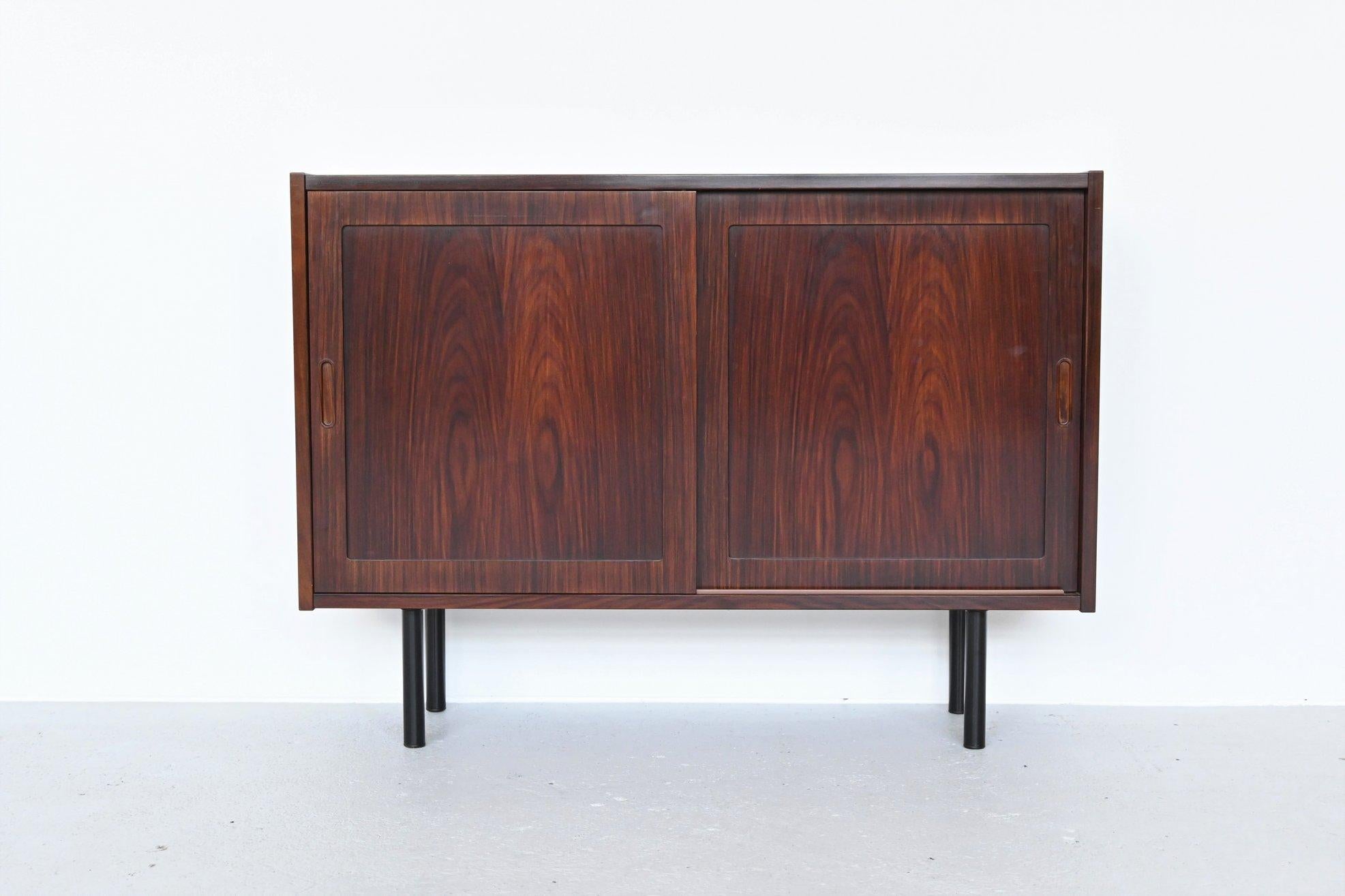 Very nice pair of cabinets designed by Carlo Jensen and manufactured by Hundevad & Co, Denmark, 1960. They are made of beautiful grained rosewood and have sliding doors with adjustable interior shelving. The cabinets standing on four black lacquered