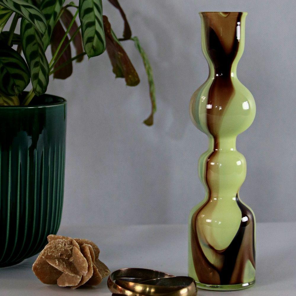 Vase en verre de Carlo Moretti, vers 1960. Travail de Murano. Marqué par l'autocollant du fabricant. Sa forme est ondulée, rendue unique par un motif continu d'ambre, de jaune, de sable et de teintes plus sombres.

Dans notre Studio, nous