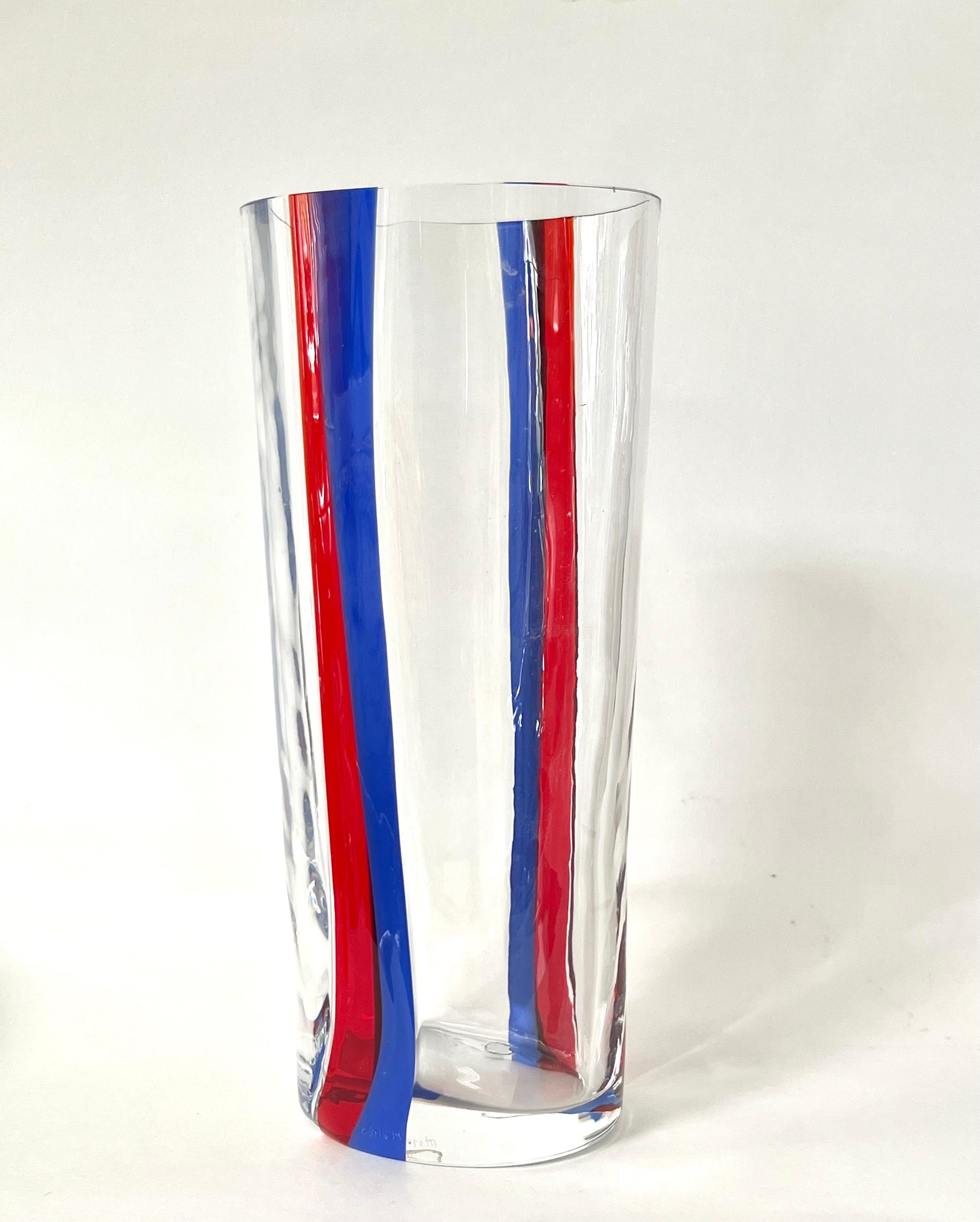 A tall Carlo Moretti Art glass vase. Clear with red and blue fluid stripes. Signed and dated.