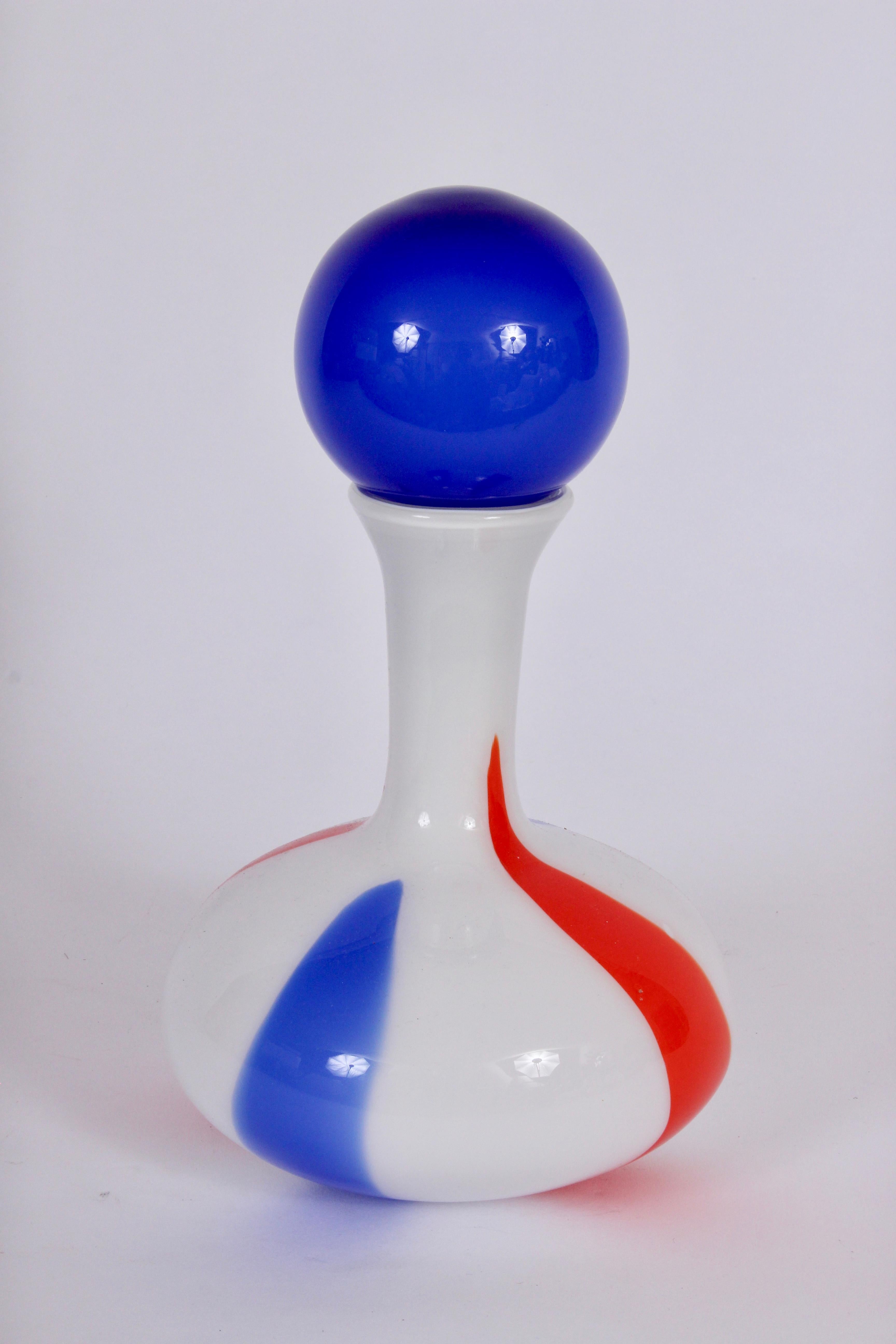 Early Carlo Moretti Italian modern marbled opaque Murano glass decanter, circa 1960. Hand crafted white, deep orange and bright blue swirl design with solid blue stopper. Heavy. Colorful. Festive. Reflective. Measures: 9.5 H to top of bottle. Like