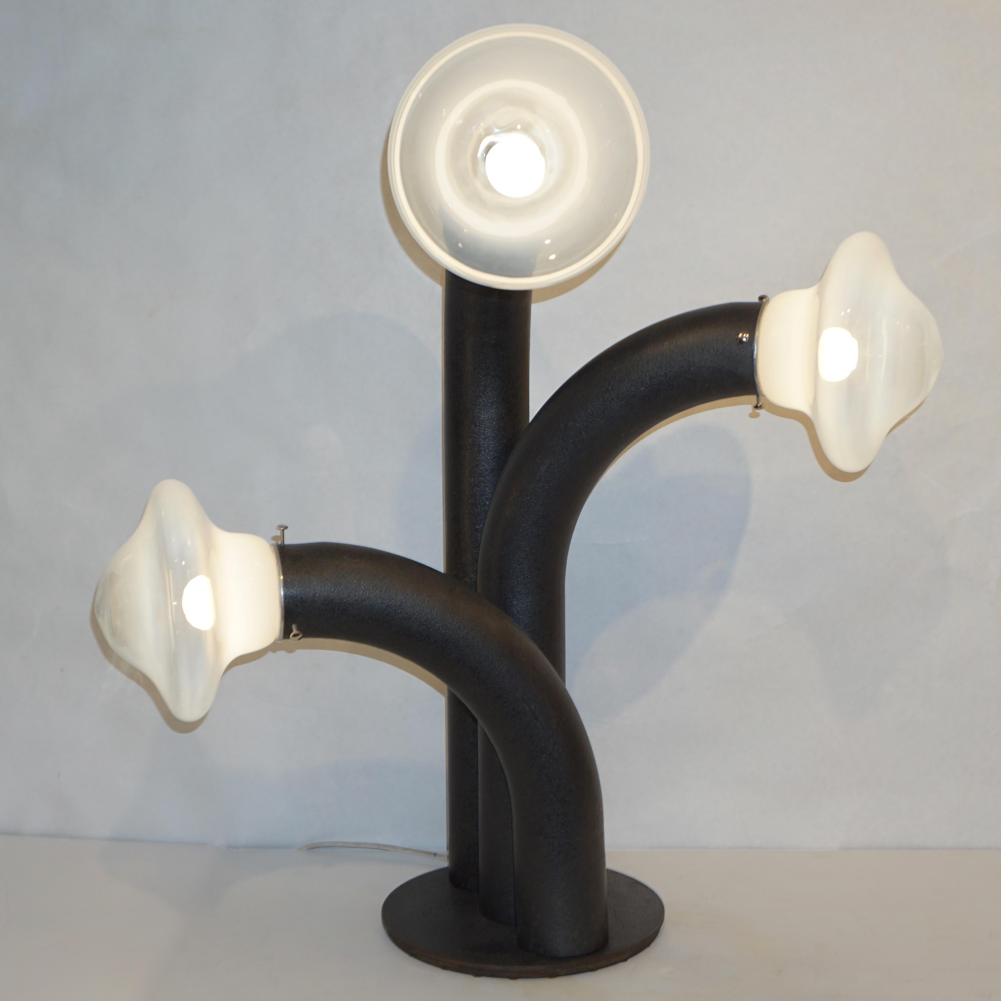 A rare one-of-a-kind Mid-Century Modern lamp by Carlo Nason, in iron with an enticing bronze finish, composed of 3 swinging curved tubes, each bearing a light source enclosed in a blown milky glass shade with mushroom shape, raised on a round slim