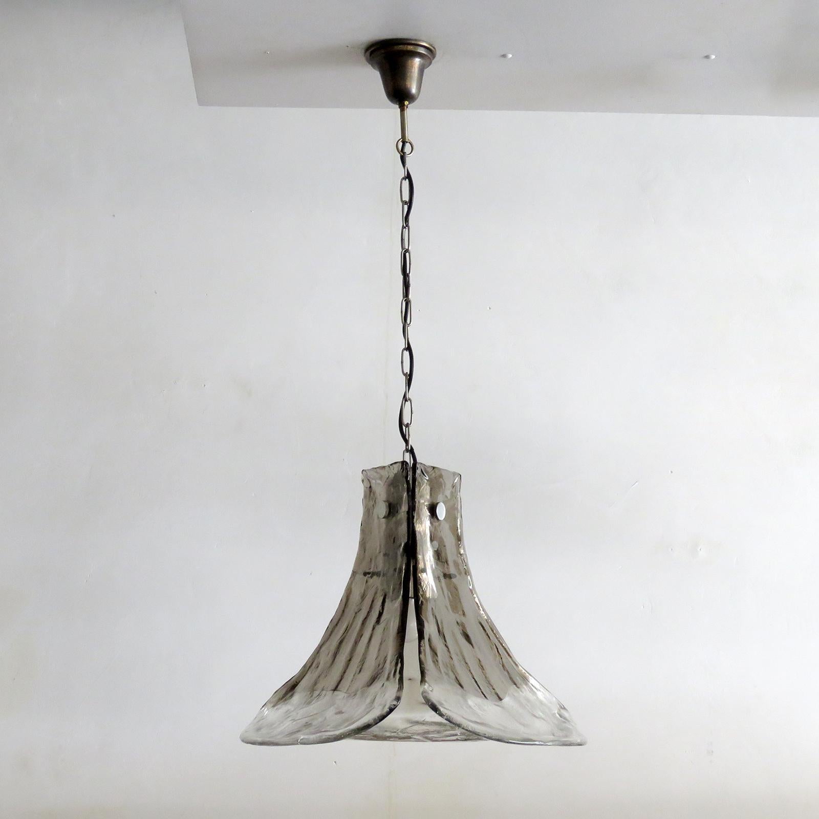Splendida lampada a sospensione floreale di Carlo Nason per AV Mazzega, Italia e J.T. Kalmar, Austria, con tre petali in vetro di Murano trasparente e fumé realizzati a mano e sostenuti da una struttura in metallo nichelato, sospesi da una catena,