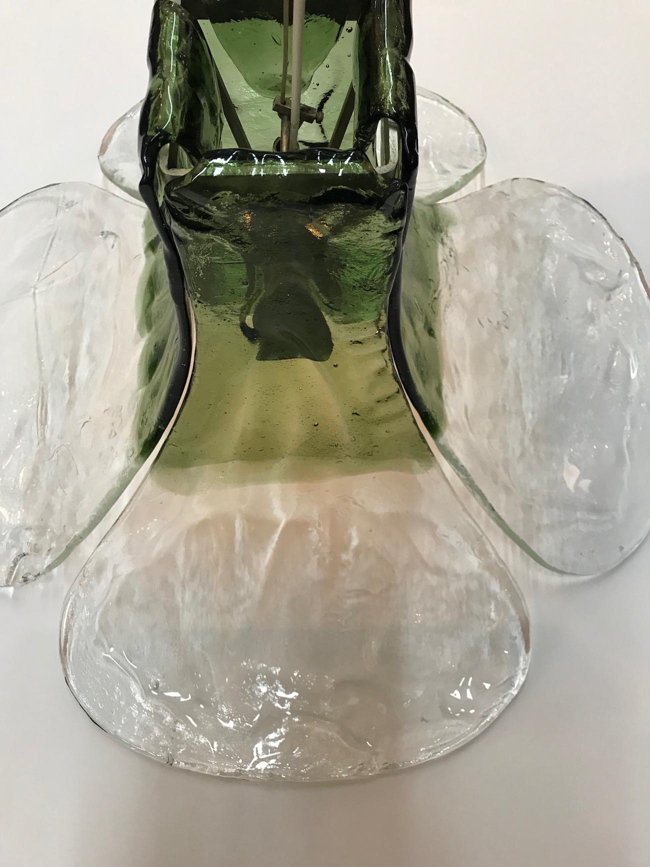 Known as model LS 185, this large glass light was designed in the 1970s by famed Italian designer Carlos Nason for the lighting house Mazzega. Each of the four glass petal is hand formed in clear with green color glass. The petals curve from the