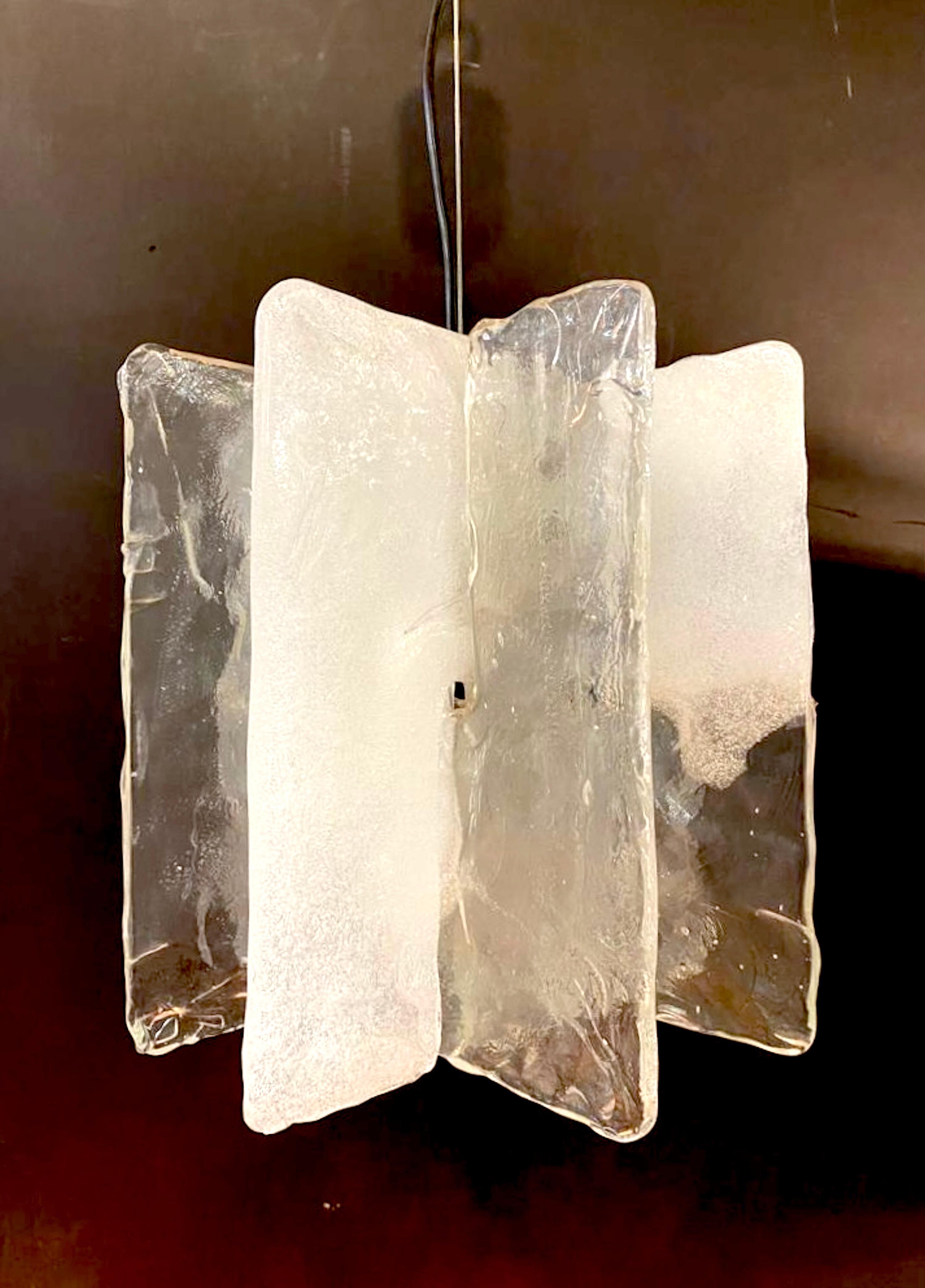 Magnifique lustre au design moderne des années 1970, réalisé par le célèbre designer italien Carlo Nason. Conçue et produite pour la société italienne d'éclairage Mazzega. Ce lustre au design simple et élégant est composé de quatre panneaux de verre