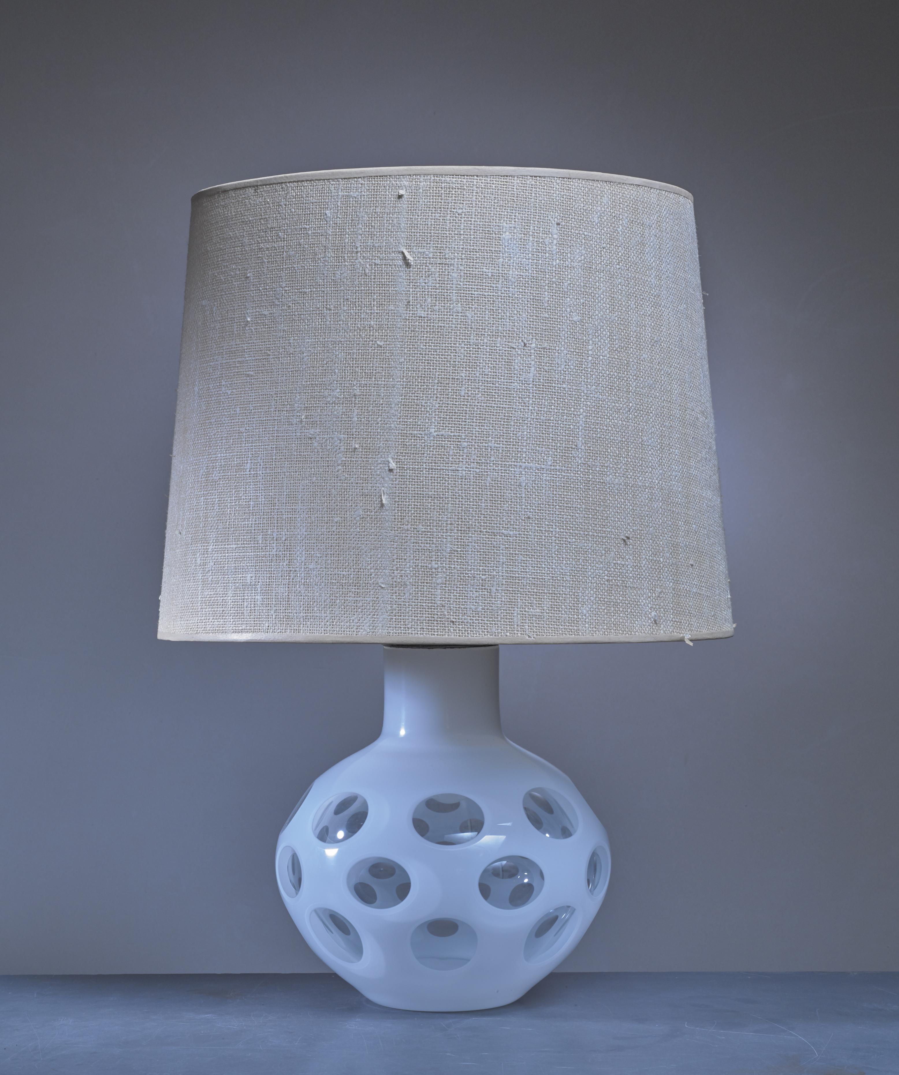 A table lamp by Carlo Nason for Mazzega. The lamp is made of a glass base, painted white with transparent parts, with a brass fitting on top. Inside the base is a small lamp.

The measurements and shipping costs stated are of the lamp without a