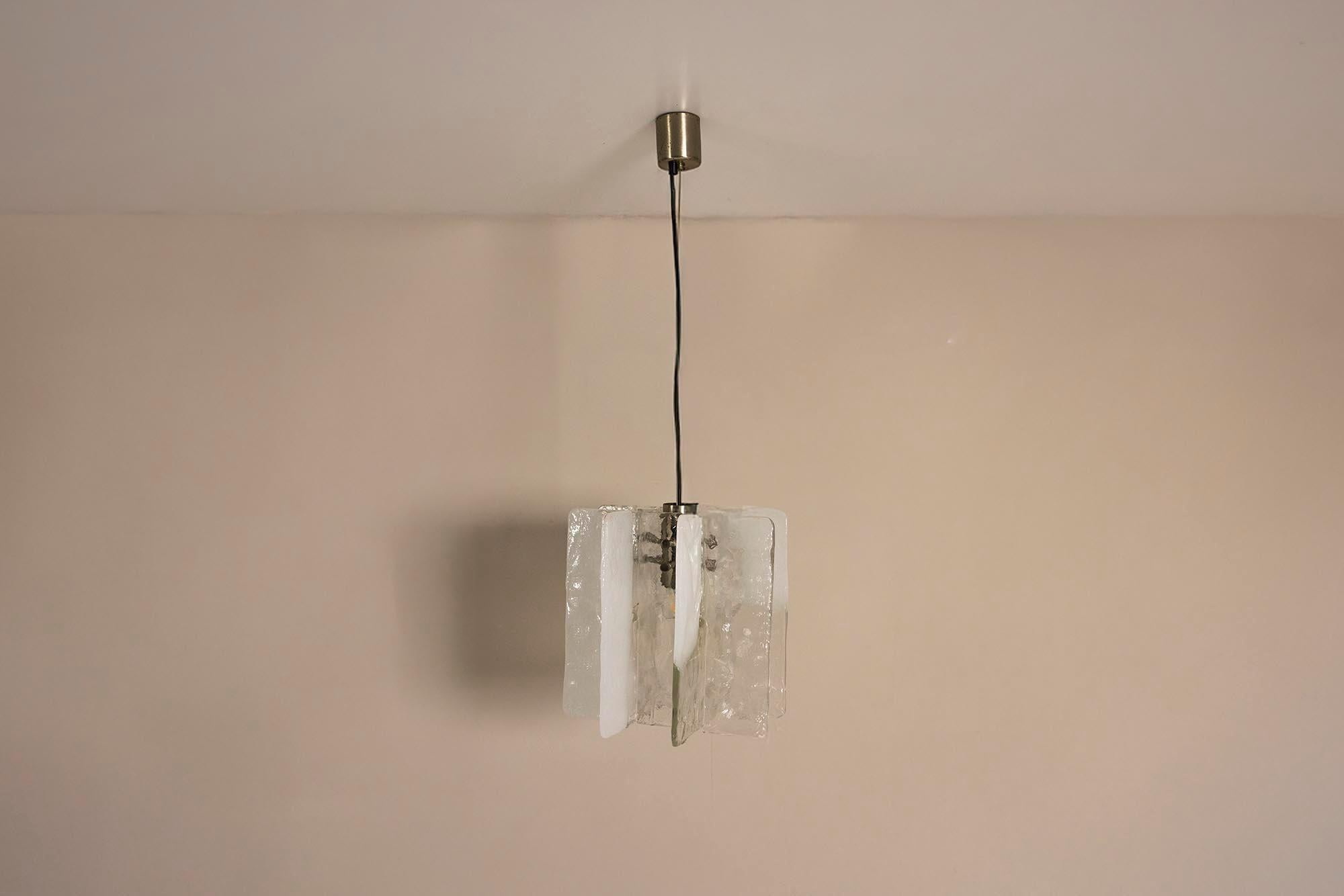 Un juego de formas fundidas y luz suave, esta lámpara colgante de Carlo Nason muestra el cristal de Murano en su forma más arquitectónica. Diseñado para AV Mazzega en la década de 1970, el modelo LS 192 refleja el movimiento de la época hacia una