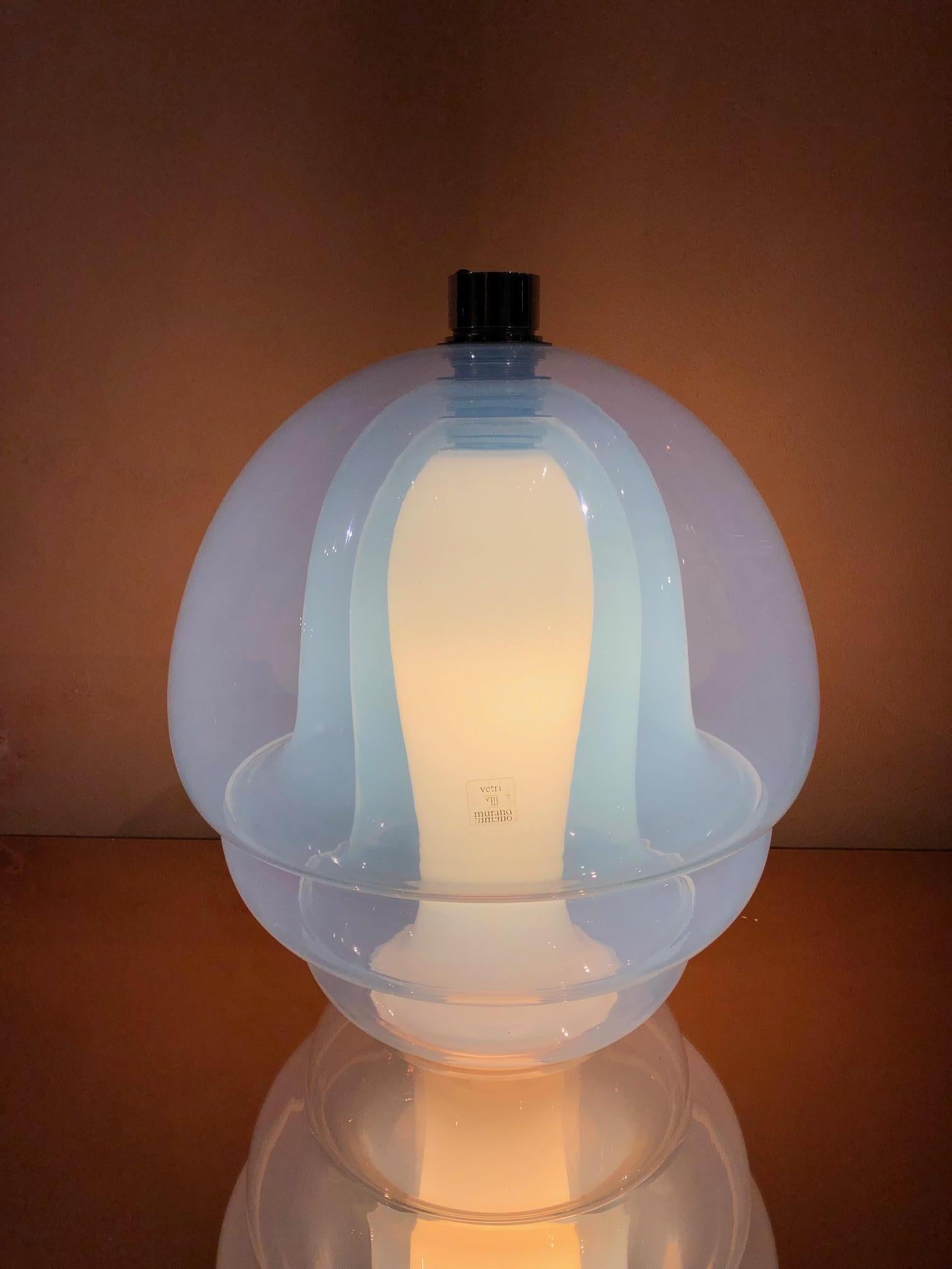 Le plus beau lustre conçu par Carlo Nason pour le verrier de Murano Mazzega dans les années 1970. Modèle LS 134 sur le catalogue Mazzega de 1970. Quatre éléments concentriques en verre bleui transparent et lait blanc divisés par des disques en