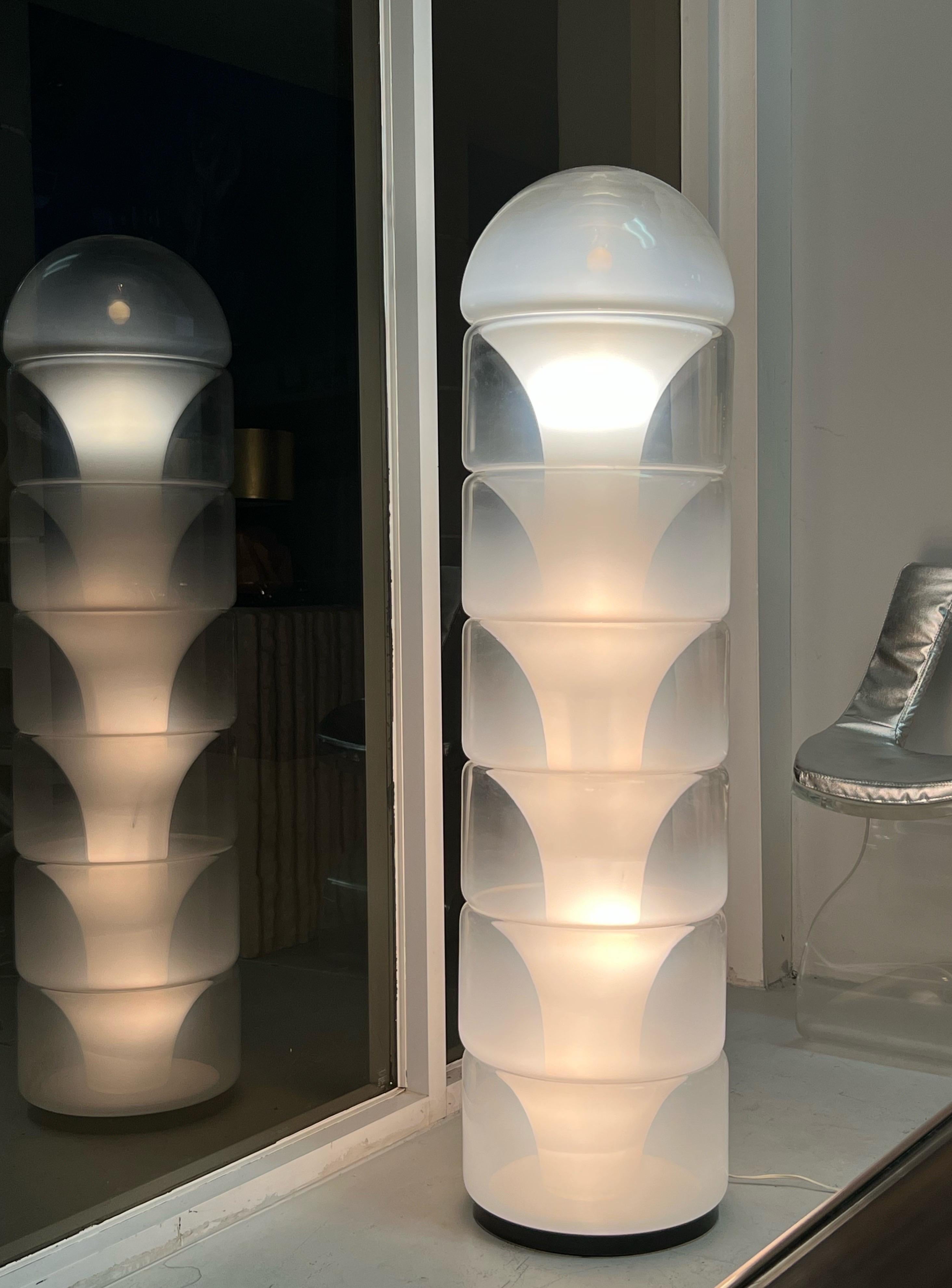 Iconic lamp by Carlo Nason. 7 heavy Murano glass elements arranged in a column and internally lit create a quite unique visual experience. The base is metal with a bronze patina.