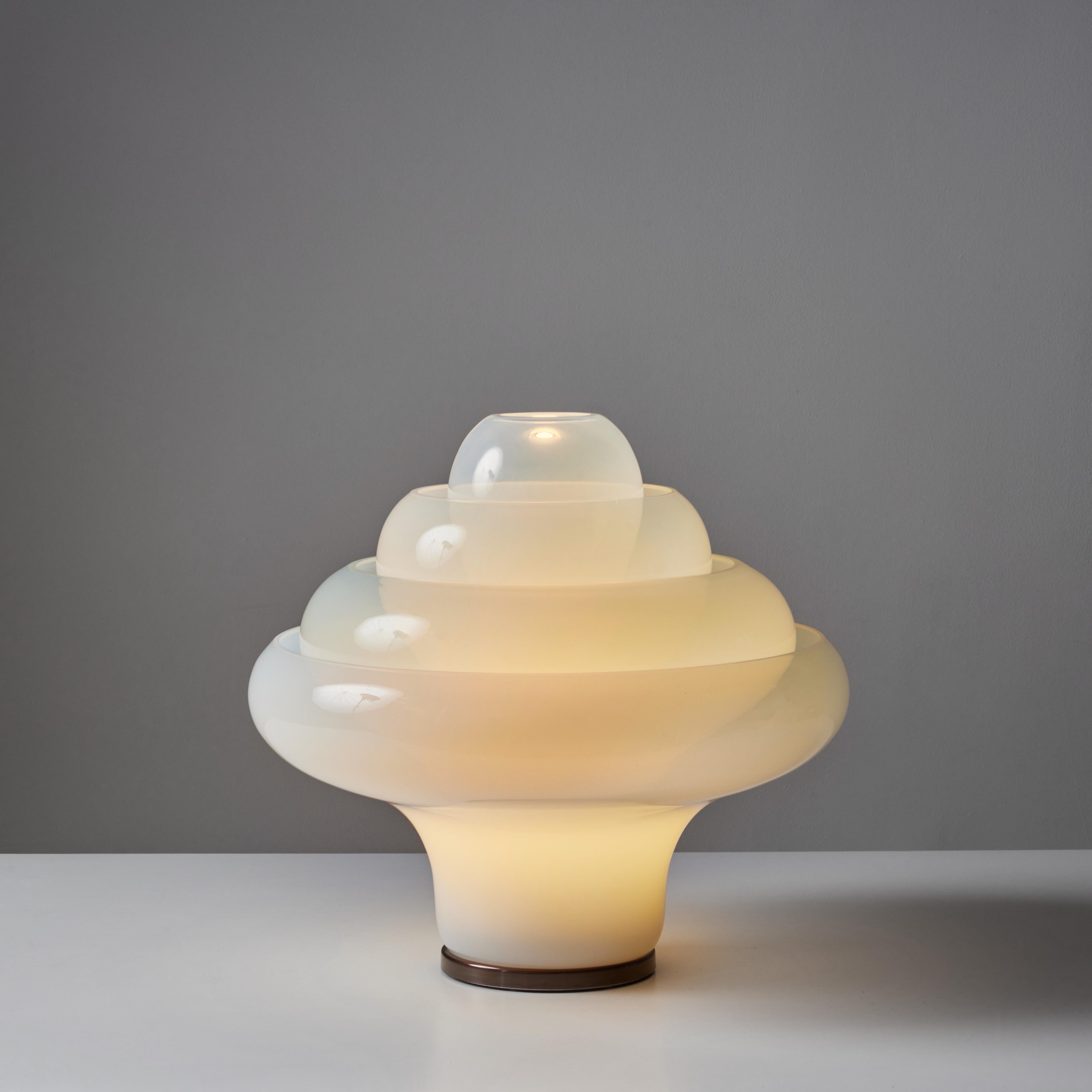 Table lamp by Carlo Nason for Mazzega c.1970s, Italy, is sure to light up any room in your home. The lamp features four glass pieces inset to one another forming a lotus shape. The Model LT305 blown Murano glass lamp is set on a round bronzed