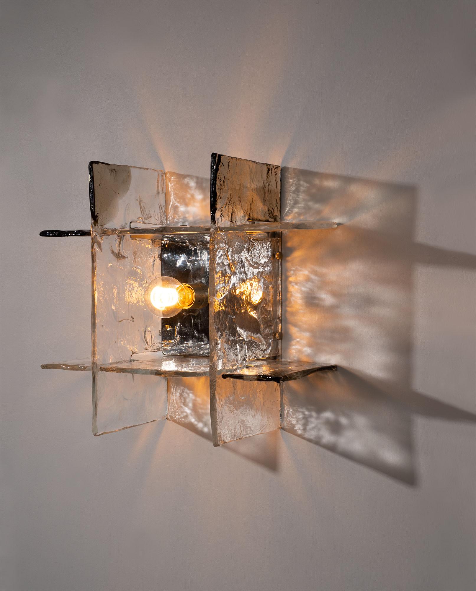 Diseñado por Carlo Nason para AV Mazzega en Italia entre 1970 y 1979, este escultural candelabro moderno de mediados de siglo ejemplifica el arte y la innovación del diseño en cristal de Murano. La pieza presenta cuatro grandes elementos de vidrio