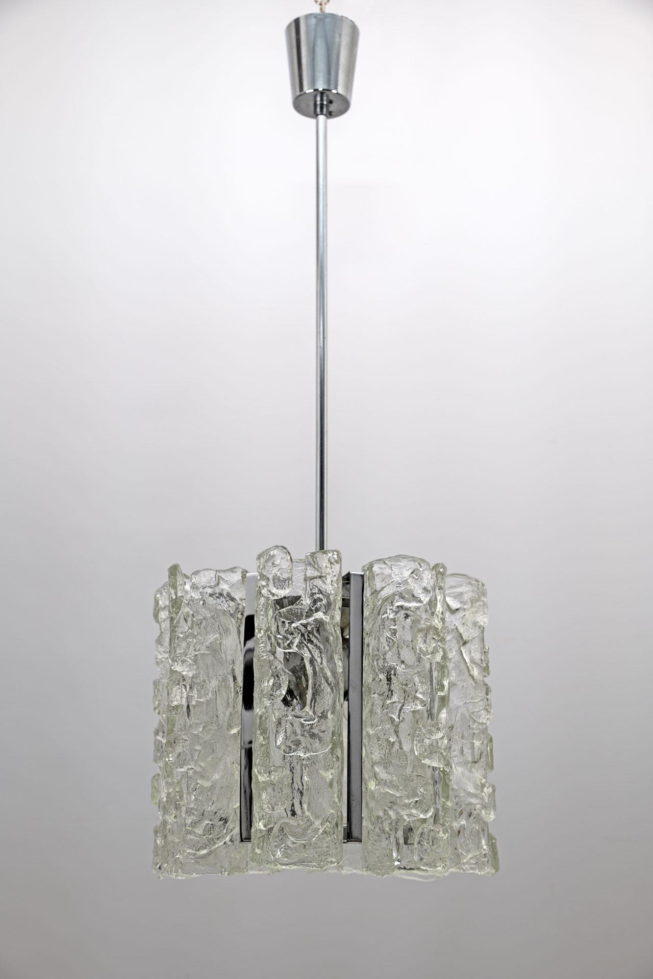 Beautiful Murano glass chandelier, created by Carlo Nason for Mazzega in the 1970s, the chandelier is composed of eight cylindrical cannulas 31 cm high and a blown glass disc, the structure is made of steel, illuminated by four light bulbs.