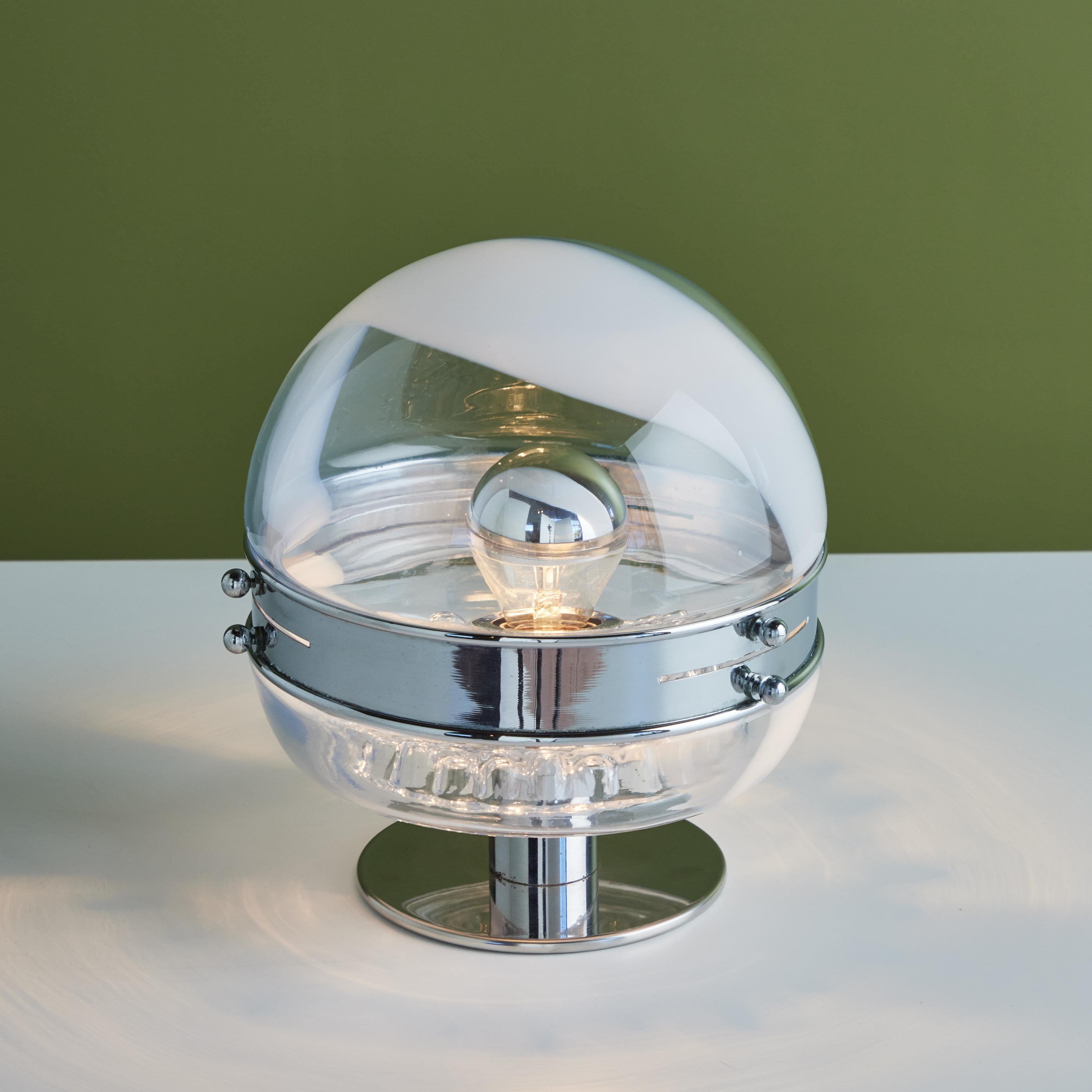 La lampe de table en verre soufflé de Carlo Nason pour Leucos c.1970, Italie, ne manquera pas d'illuminer n'importe quelle pièce de votre maison. La lampe présente un globe rond en verre avec un bandeau en verre de lait blanc. La partie inférieure
