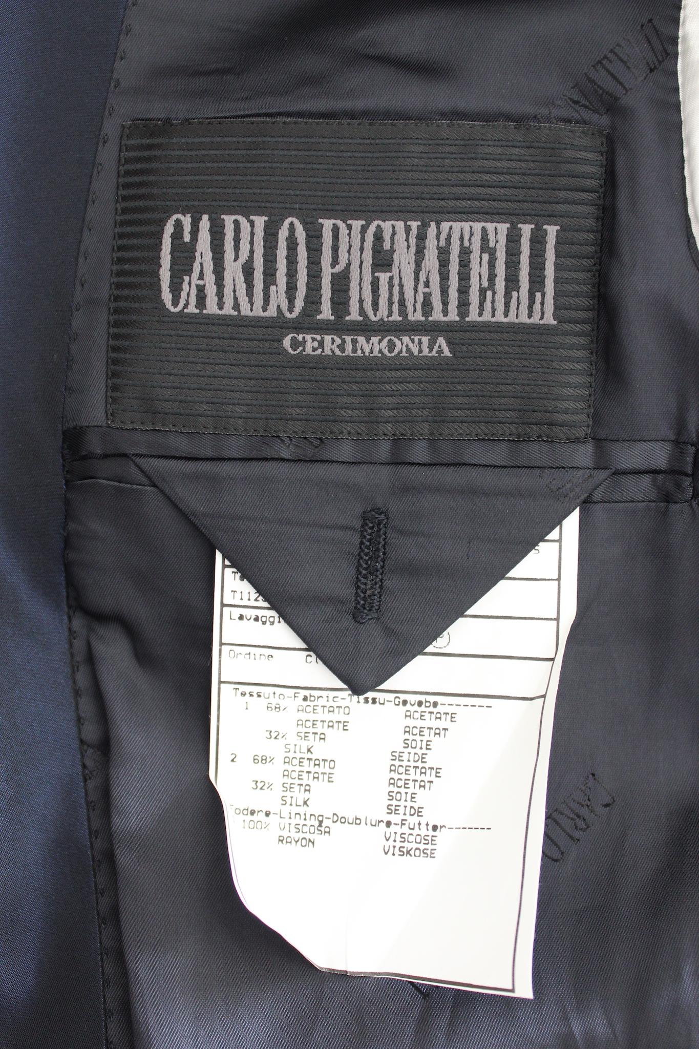 The Carlo Pignatelli pants suit is a sophisticated and elegant outfit, perfect for a groom or anyone attending a formal ceremony. The suit features a dark blue color that exudes a sense of formality and class. It is made from high-quality silk