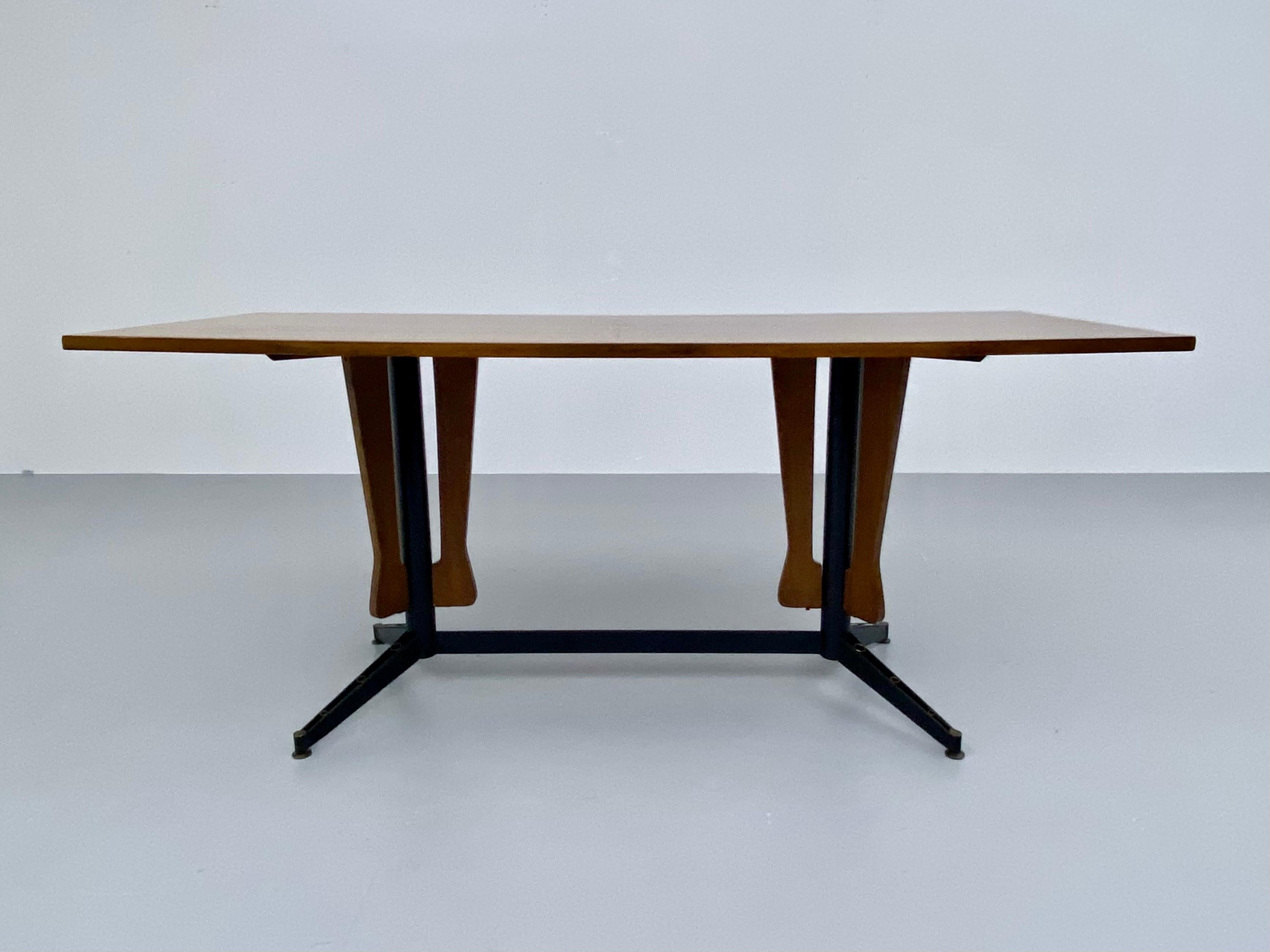 Elegant dining table with romantic steel base. The top has been lacquered and is quite shiny and in very good condition. The shape of the top is slightly tapered towards the sides. The frame is made of steel with some nice typical Carlo Ratti
