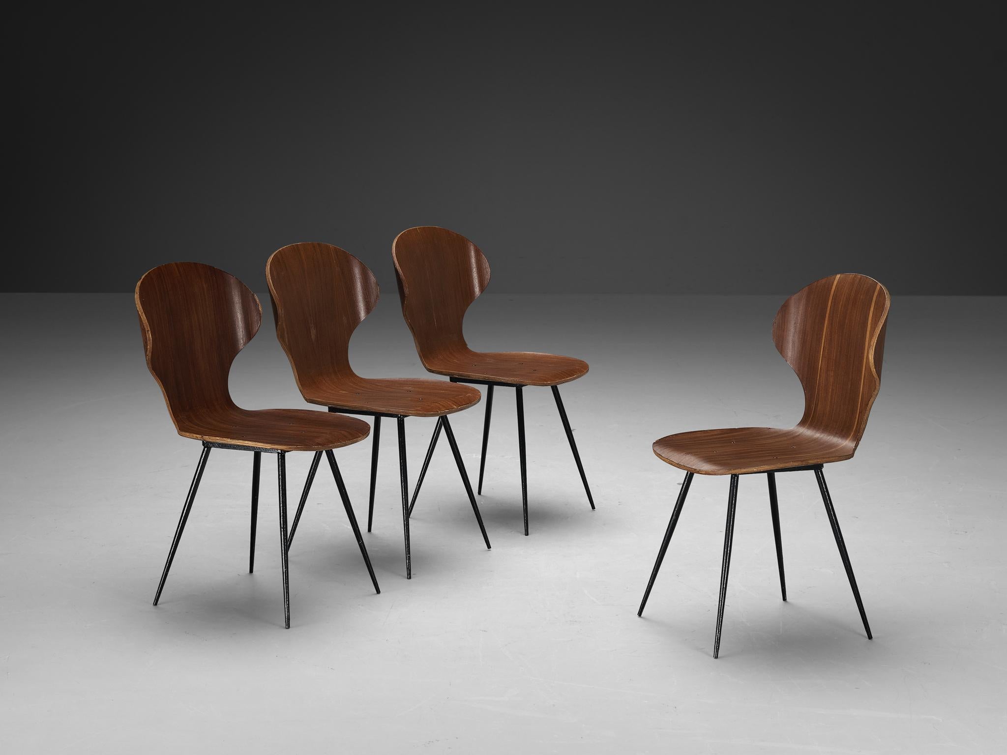 Carlo Ratti for Industria Legni Curvati, set of four dining chairs, plywood with a teak fineer and metal, Italy, 1970s.

Elegant set of Italian dining chairs with metal frame and plywood seats. The seat features a wingback with remarkable curves.