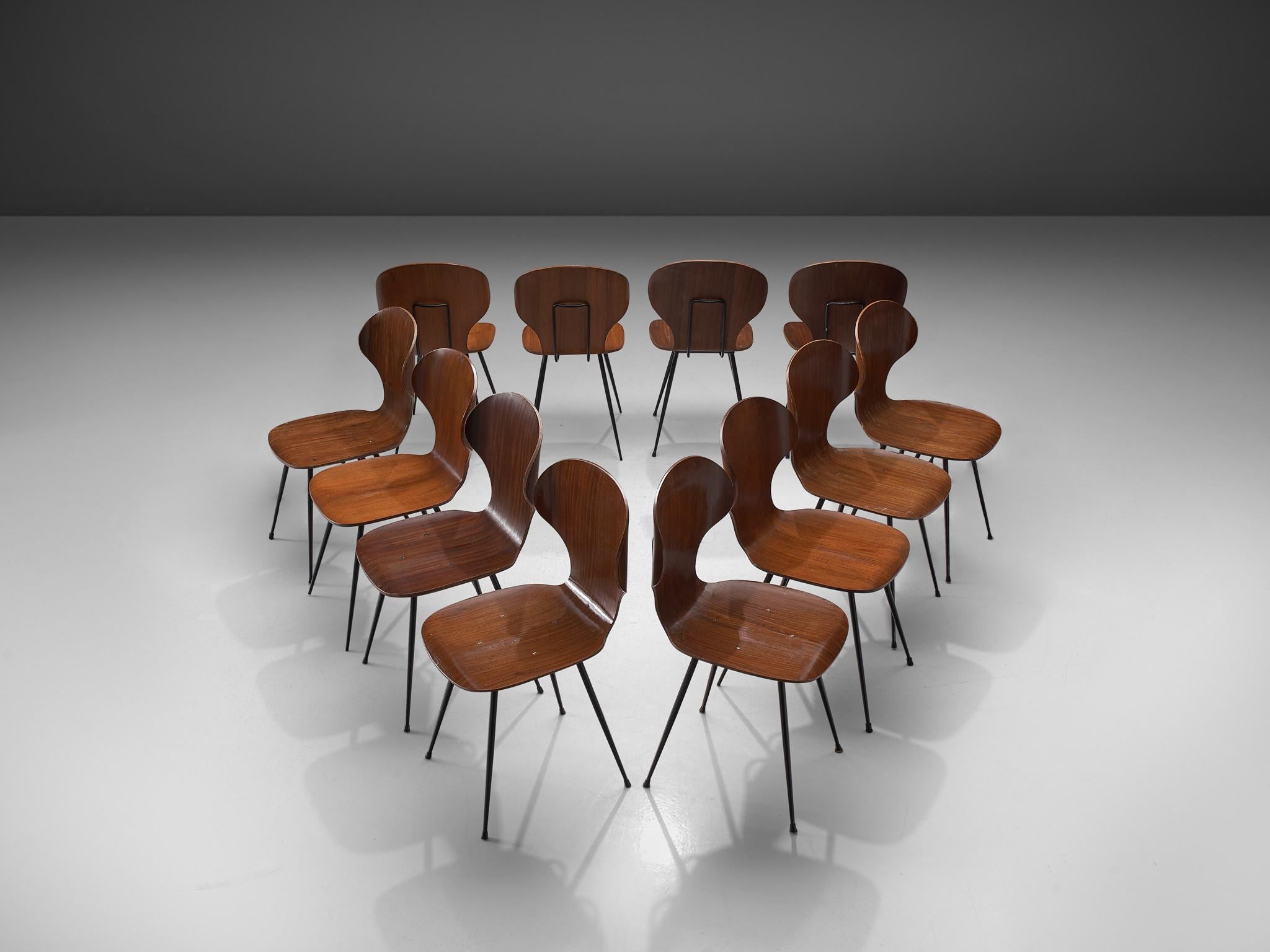 Carlo Ratti for Industria Legni Curvati, set of twelve dining chairs, plywood with a teak fineer and metal, Italy, 1970s.

Elegant set of Italian dining chairs with metal frame and plywood seats. The seat features a wingback with remarkable curves.