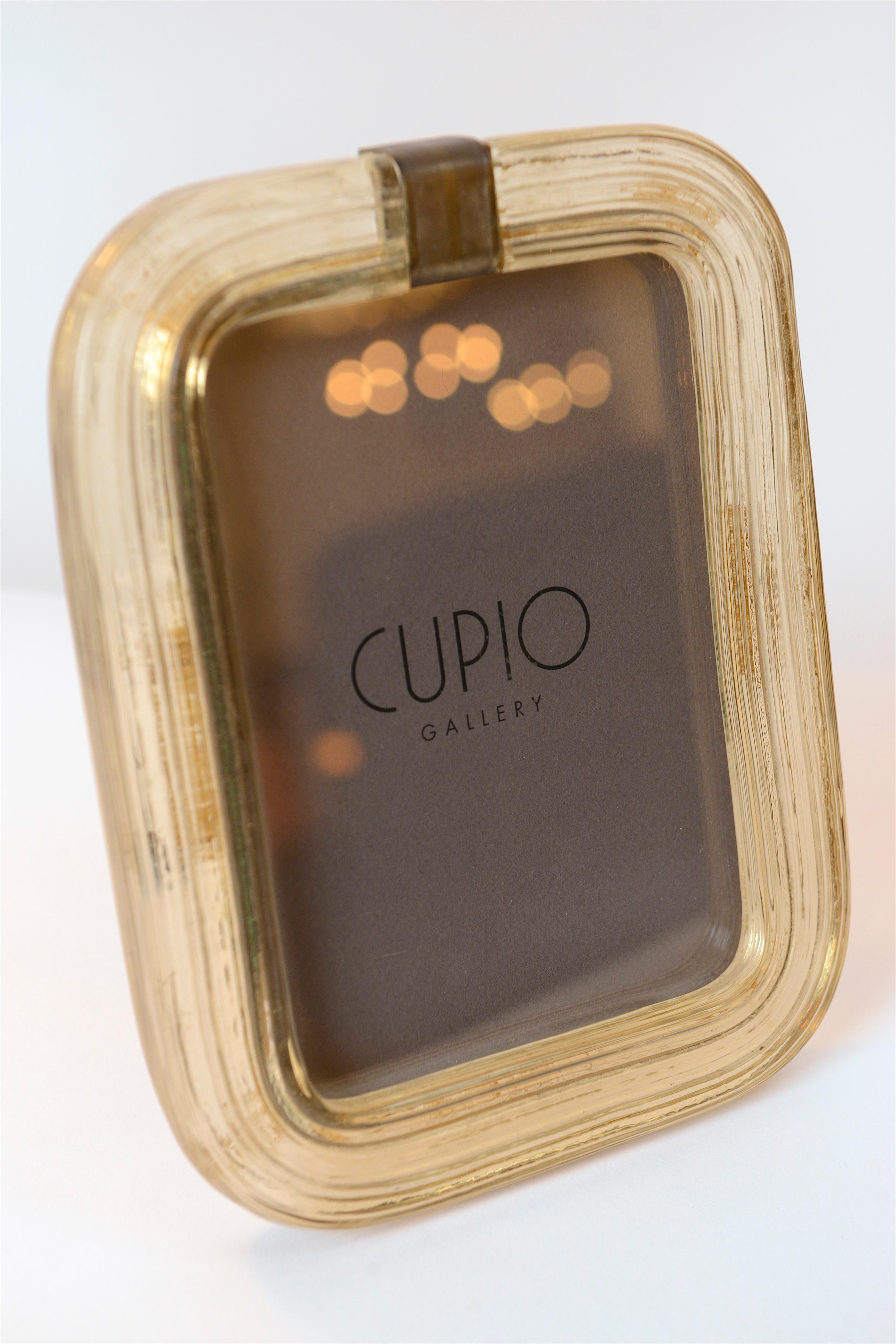 A particularly beautiful 1940s picture frame designed by Italian architect and designer Carlo Scarpa. Produced by the prestigious Muranese Company, Venini, this honey colored piece was made using the ‘Battuto’ glass making technique. Deep vertical