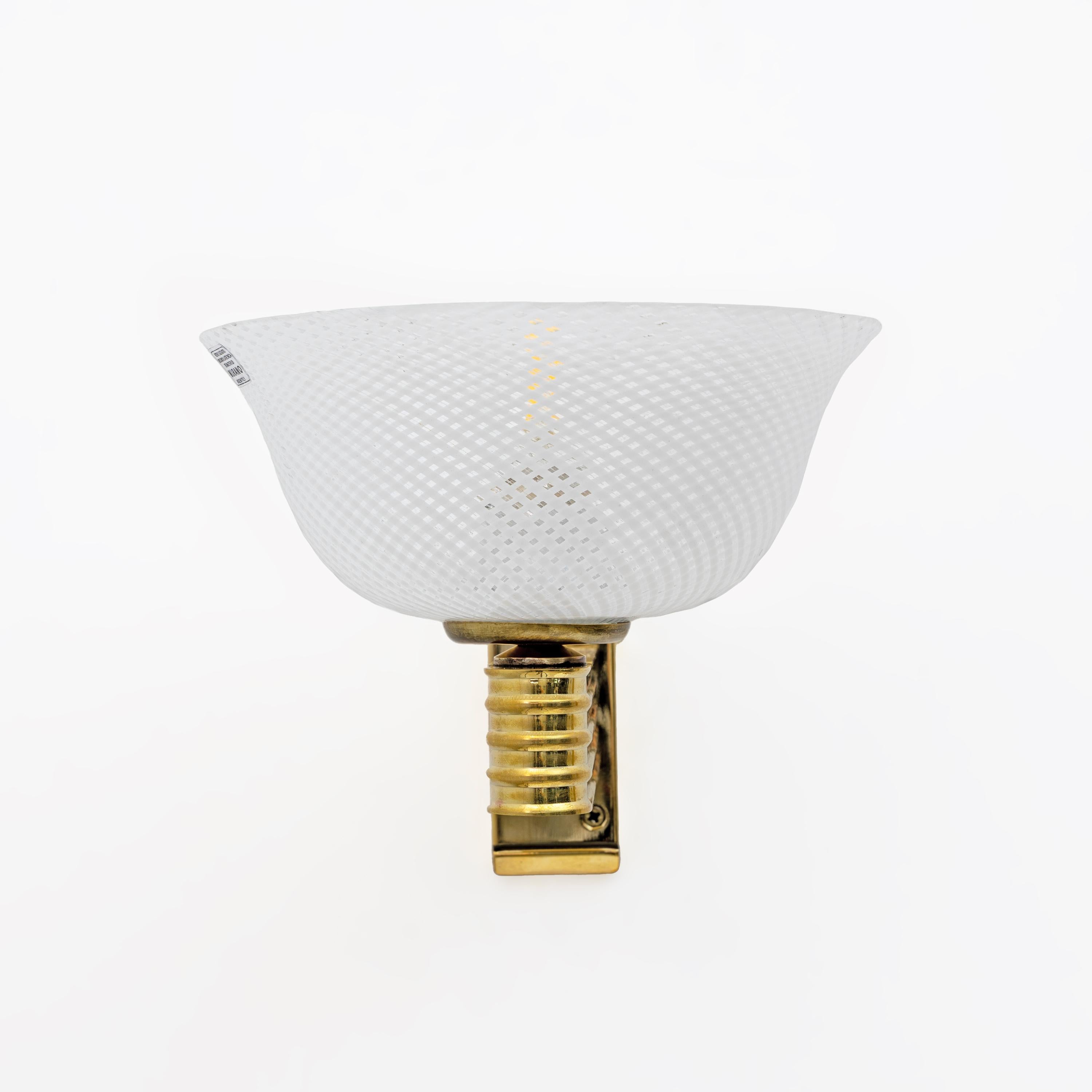 Ces splendides appliques en verre de Murano ont été conçues par Carlo Scarpa pour Venini. Elles sont entièrement fabriquées à la main selon la technique du Reticello, appelée ainsi en raison de la texture caractéristique en forme de filet visible à
