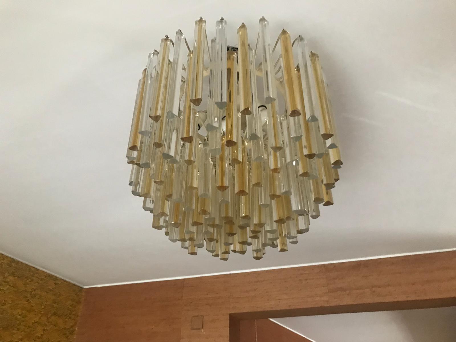 Suspension chandelier designed by the famous designer Carlo Scarpa for Venini. Its simplicity and its elegance makes it a chandelier suitable for every style. Composed of a metal structure and glass of Murano elements.