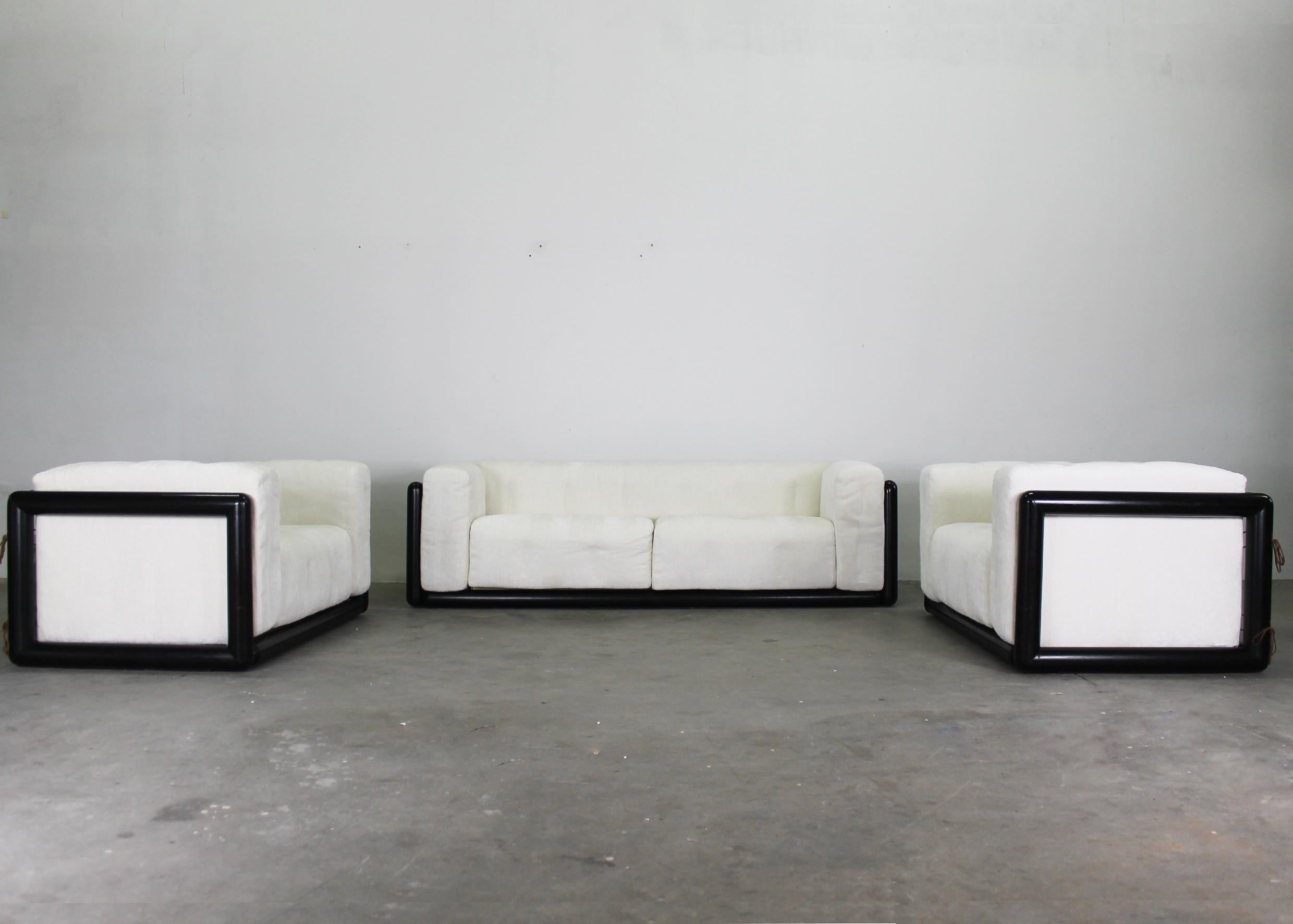 Cornaro living room set is composed of a two-seater sofa with two armchairs, a frame in lacquered wood seat, and a back in padded fabric, with leather ties. 
Designed by Carlo Scarpa for Simon Gavina, 1970s. 

Dimensions:
H63 x 220 x 86 cm