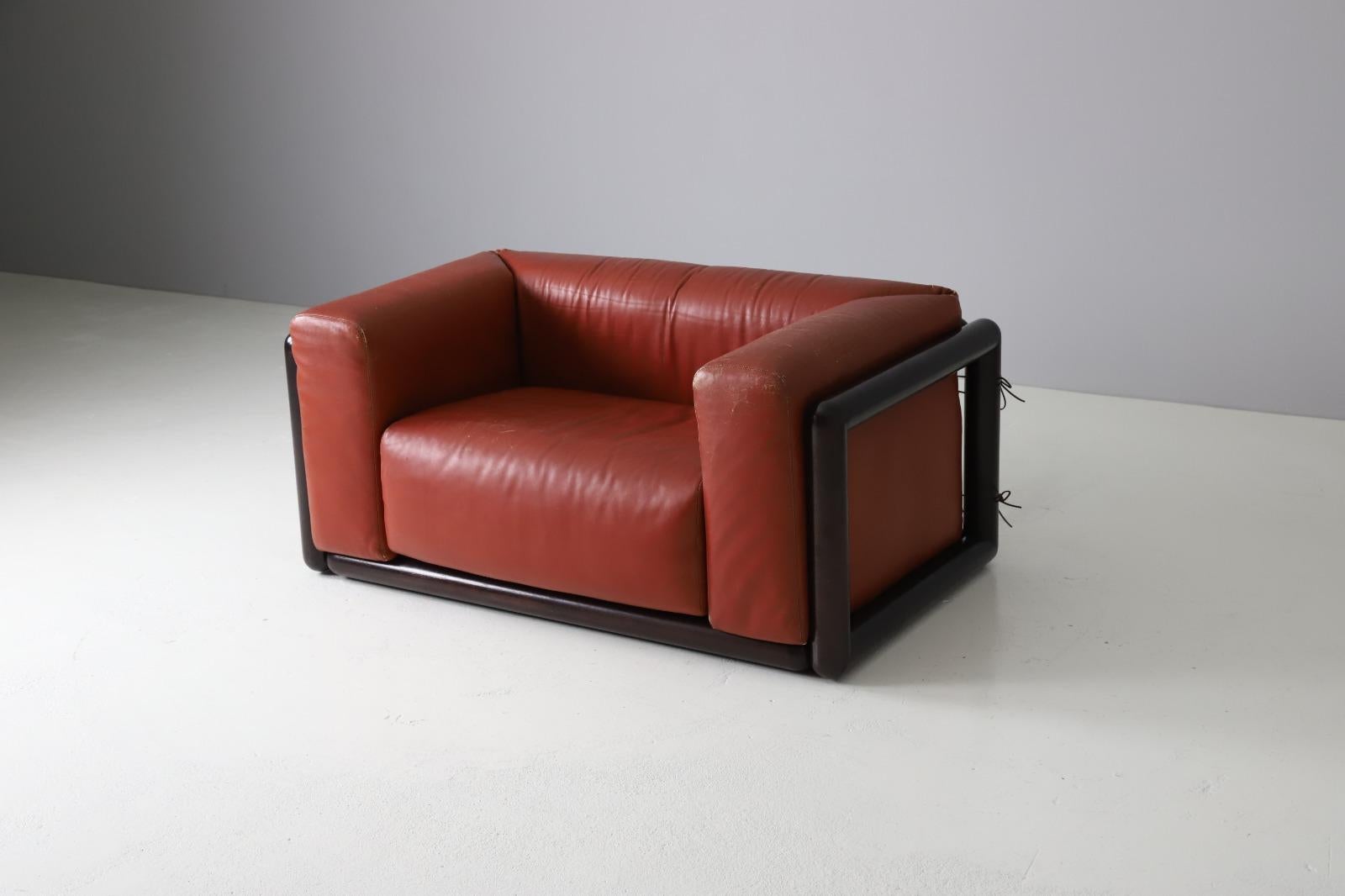 'Cornaro' loveseat sofa designed by Carlo Scarpa, Italy 1973. Made out of solid dark stained mahogany with leather upholstery. The original leather has developed a stunning patina over the years . The foam is still perfect and the cushions are