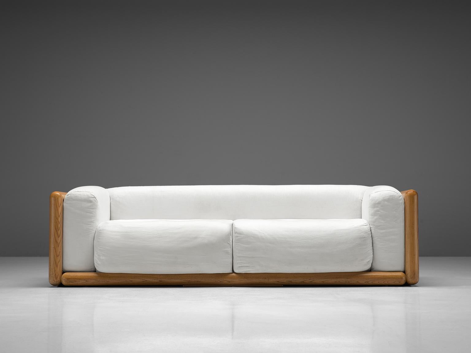 Carlo Scarpa for Simon, 'Cornaro' sofa, white fabric, ashwood, Italy, 1973

The sofa has a very thick cushion and is upholstered with white fabric. The piece have a relatively thin back and armrests compared to the seat. The frame is made out of a