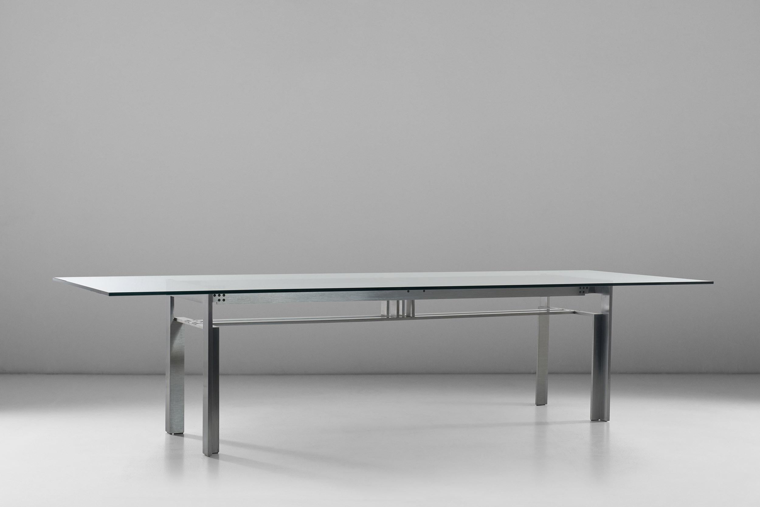 This sculptural table has become an emblem of Italian design, a trademark of the '60s rational movement. The architectural base in thick steel profiles forms the core of this iconic table with glass top, where the refined elegance of the base takes