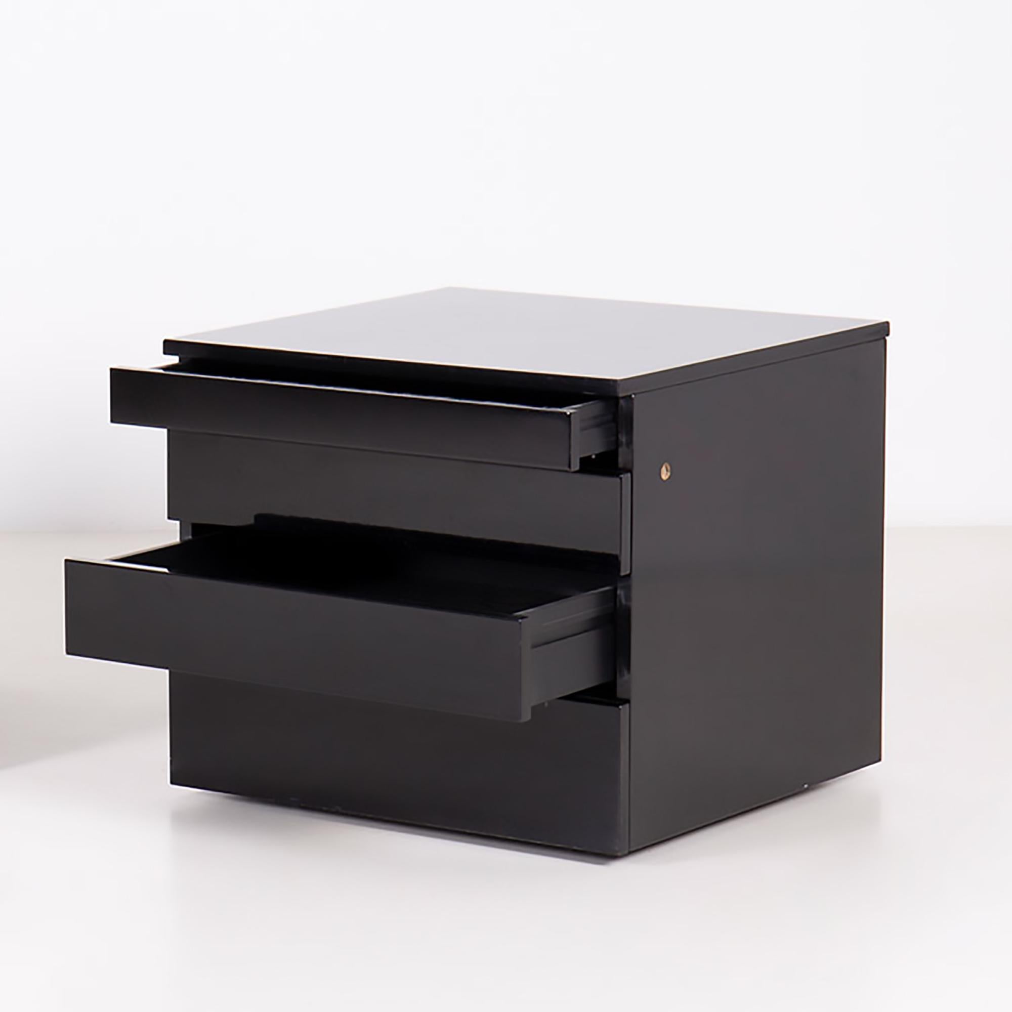 Commode à roulettes Orseolo de Studio Simon. Structure, plateau et tiroirs en bois verni polyester et finition noire brillante.
Quatre tiroirs de tailles différentes, dont le premier est muni d'une serrure de type Yale avec clé.