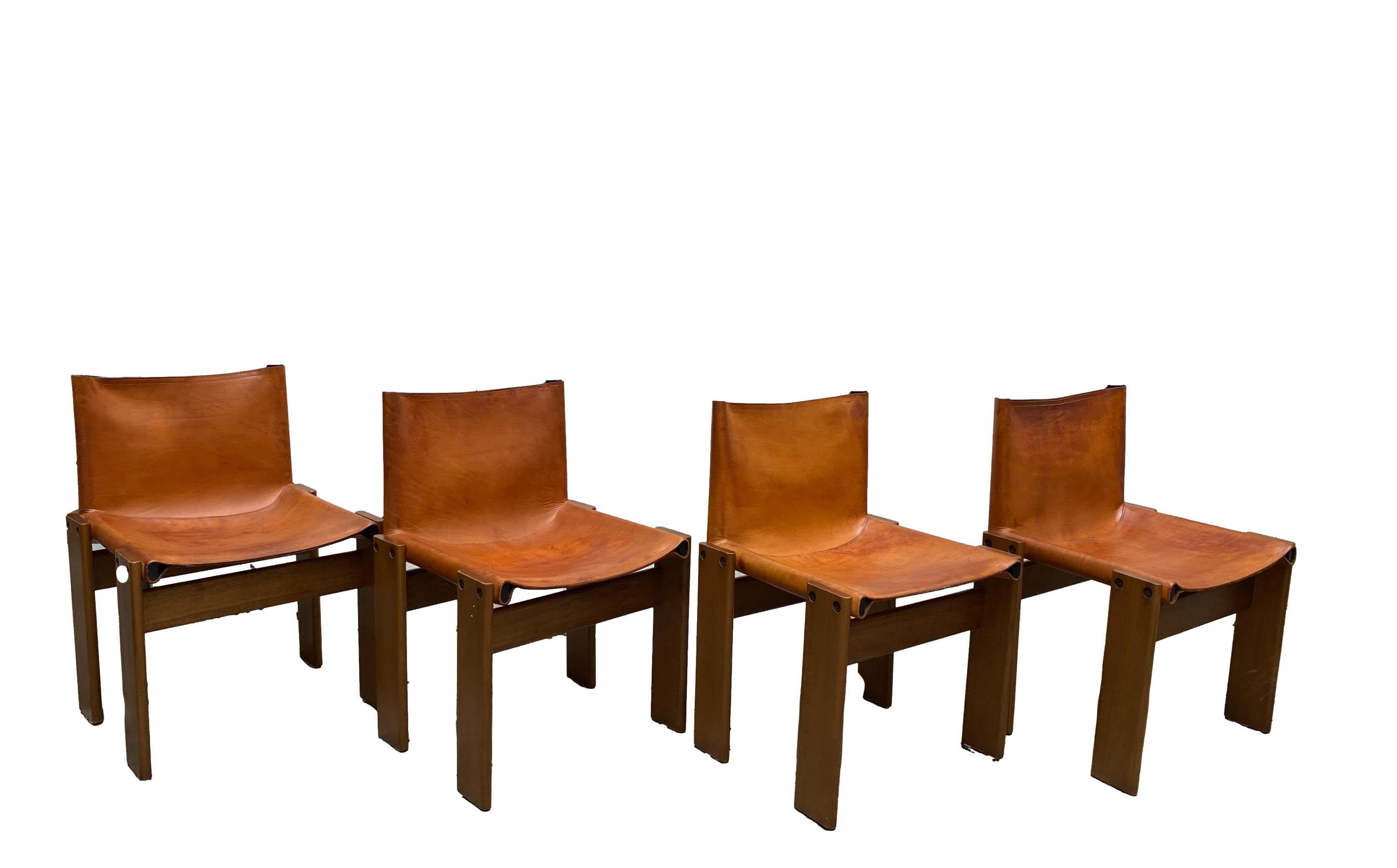 4 Chairs Mod. Monk in wood and cognac-coloured leather. Chair with seat and back in leather fitted on two steel tubes screwed to two solid wood bridges that form the ground support.