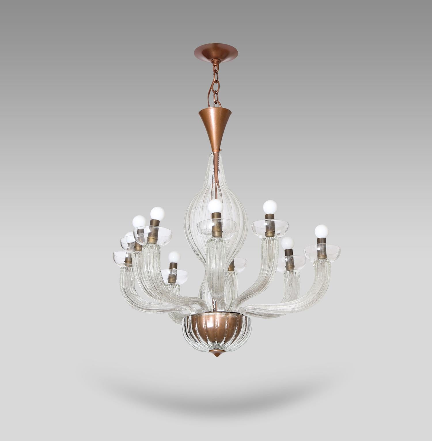 Rare 9-arm chandelier by Carlo Scarpa for Venini. Clear-colored textured glass fixture with brass mounts and gilded metal. Nine arms, each supporting a simple glass bobeche and fitted with a standard candelabra socket. This fixture has been UL