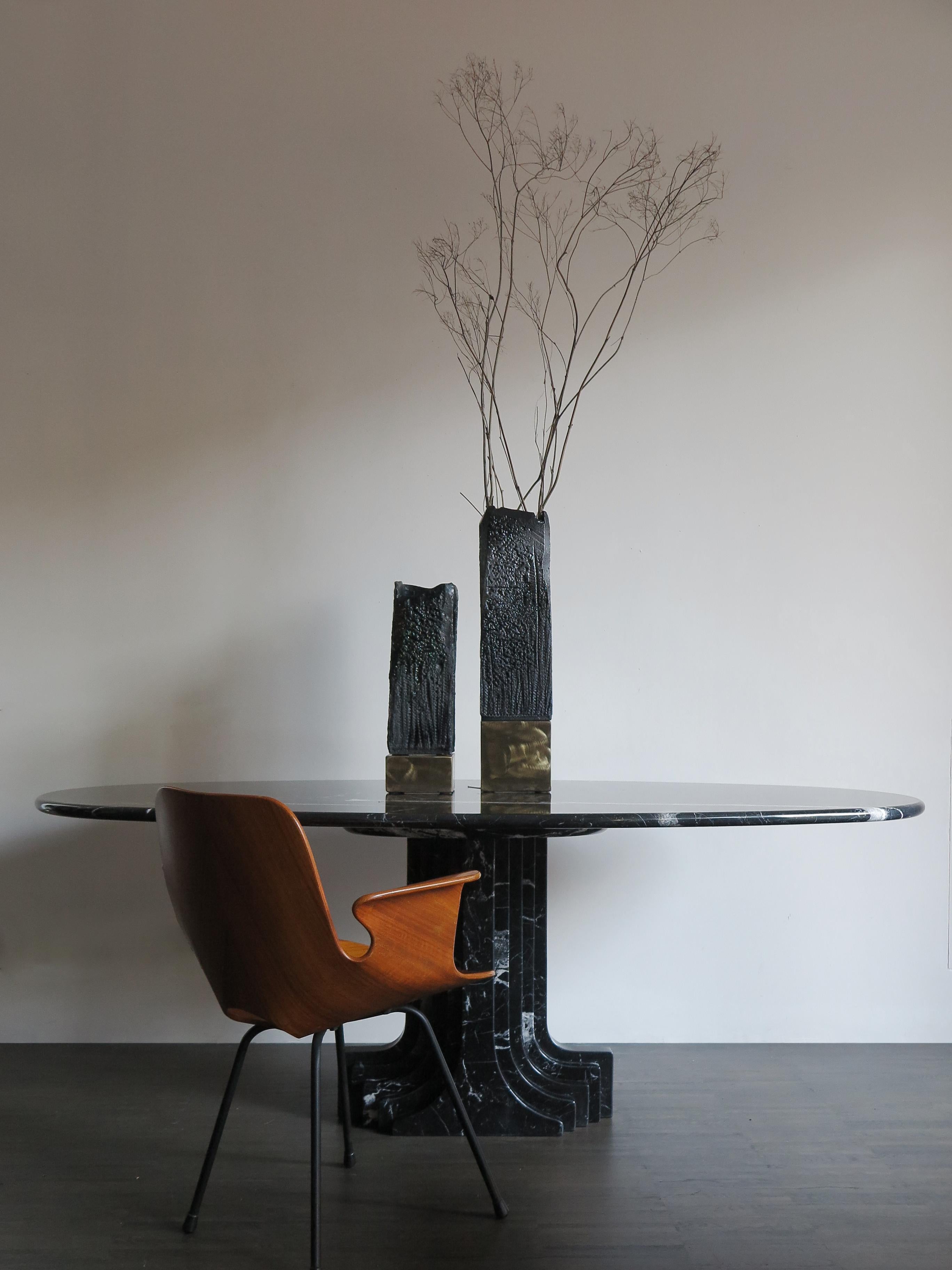 Italian dining table in black Marquinia marble model Argo, designed by Italian artist Carlo Scarpa and produced by Simon, elliptical top resting on shaped and ribbed column section leg, Italia, 1970s.
Stylized multilayered pedestal base with 9