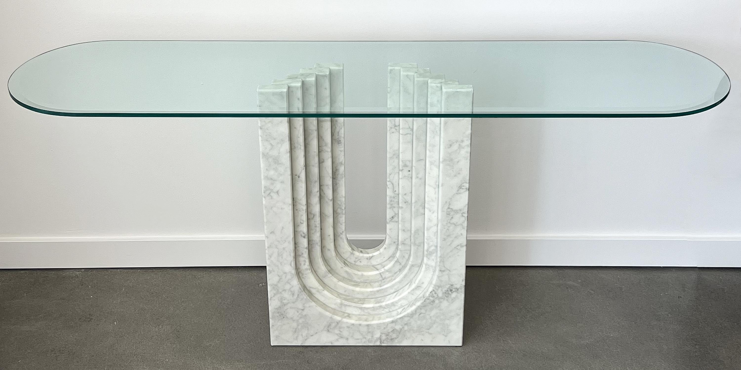 Modern white Cararra marble and glass console table by Carlo Scarpa for Cattelan Italia, circa 1970s. Five layers of stacked / stepped marble with U-shaped cutout create the sculptural pedestal for the glass top. White Carrara marble with gray