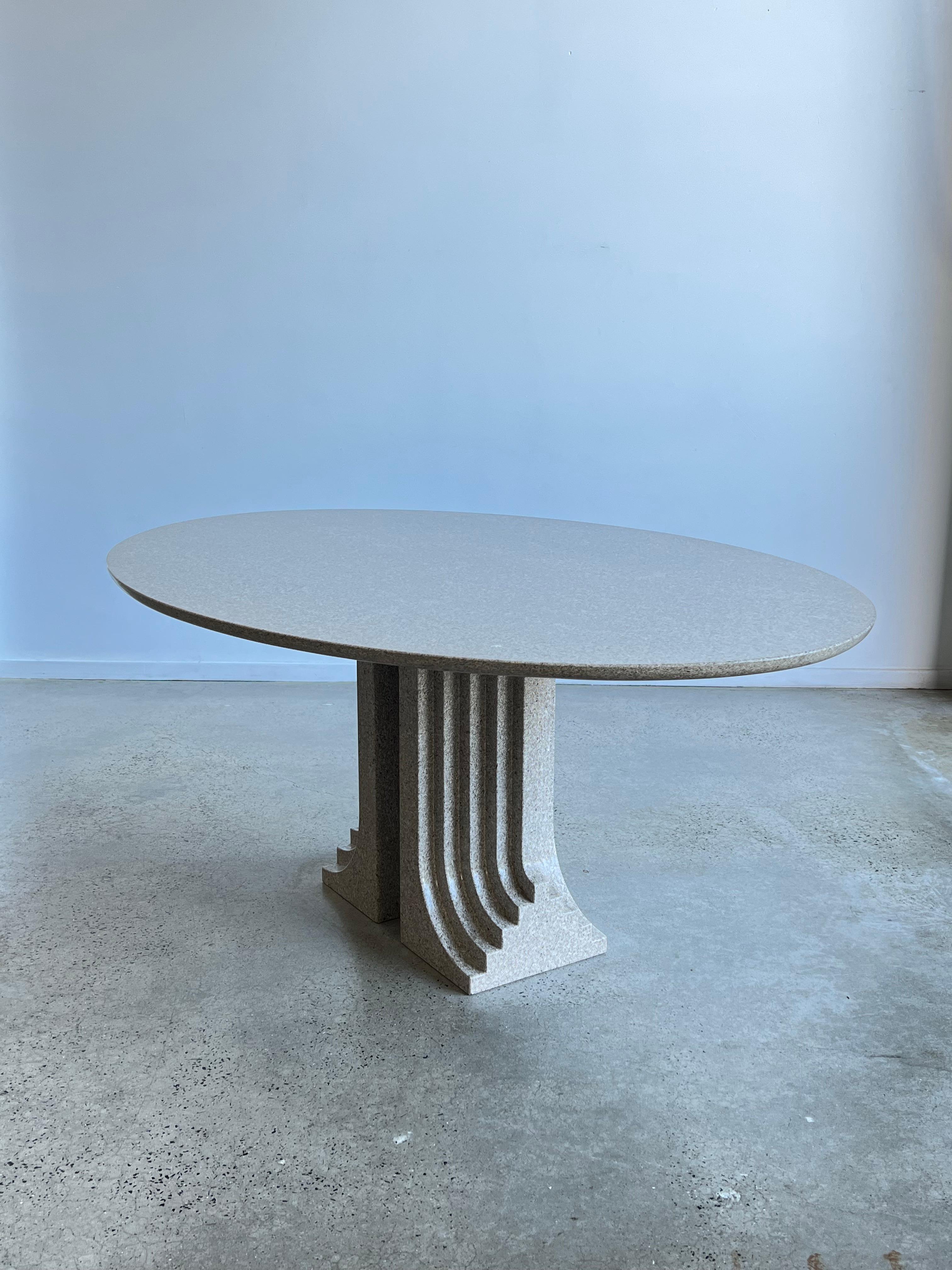 The Scarpa's way of thinking the architecture is particularly visible in this piece. The “Samo” dining table, designed in 1971 for 'Ultrarazionale' collection by Simon Gavina, consists of two grooved solid Granite pillars and a single floating oval