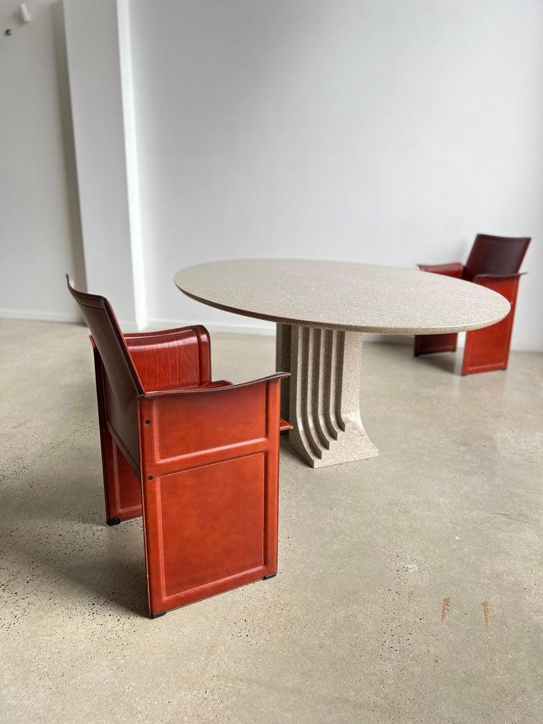 The Scarpa's way of thinking the architecture is particularly visible in this piece. The “Samo” dining table, designed in 1971 for 'Ultrarazionale' collection by Simon Gavina, consists of two grooved solid Granite pillars and a single floating oval