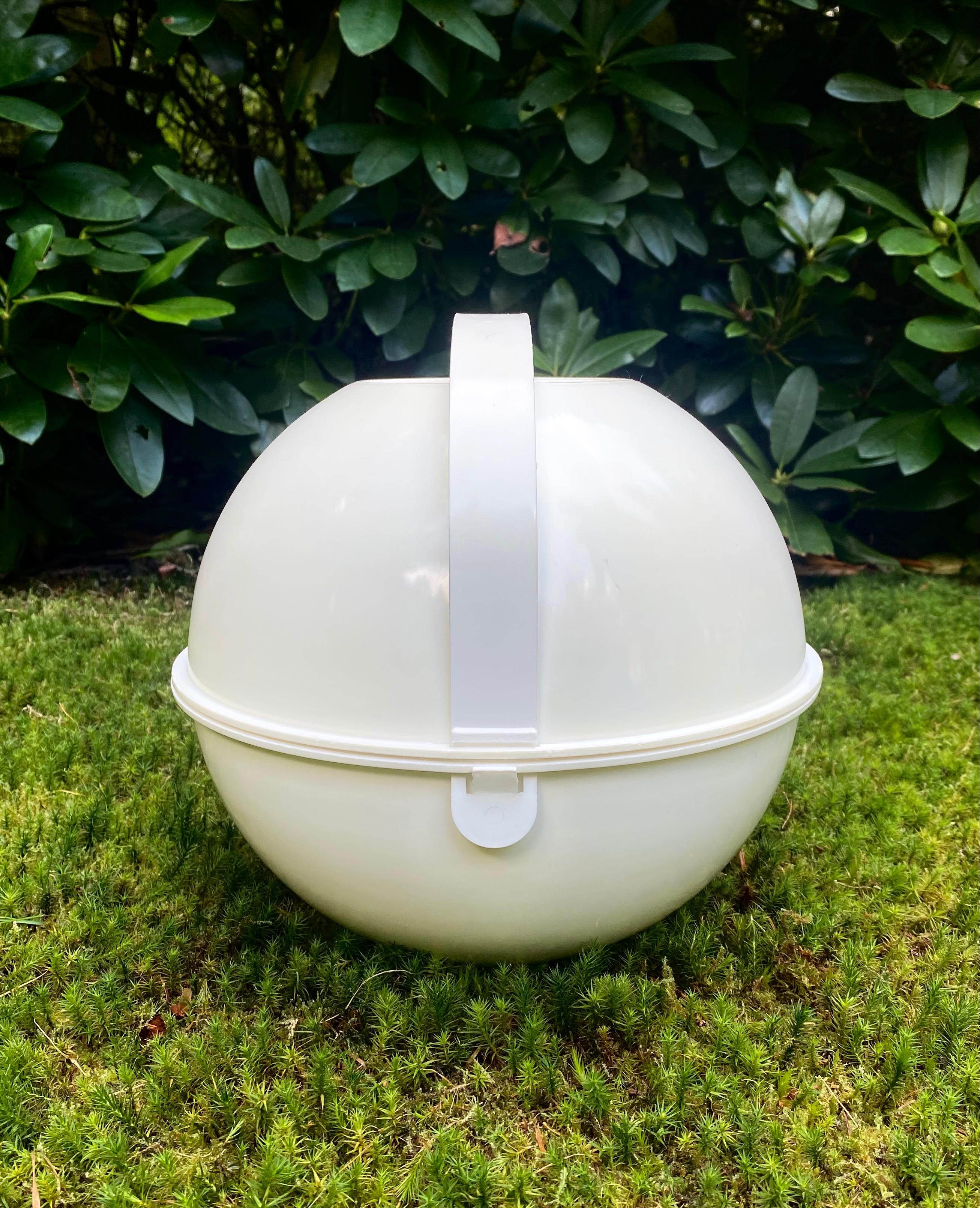 This ingenious picnic set was designed by Carlo Viglino in 1968 and produced by Guzzini in the 1970s.

The plastic sphere or ball shaped carrier holds everything required for a picnic: 2 containers, 1 tray, 6 dining plates, 6 dessert plates, 6