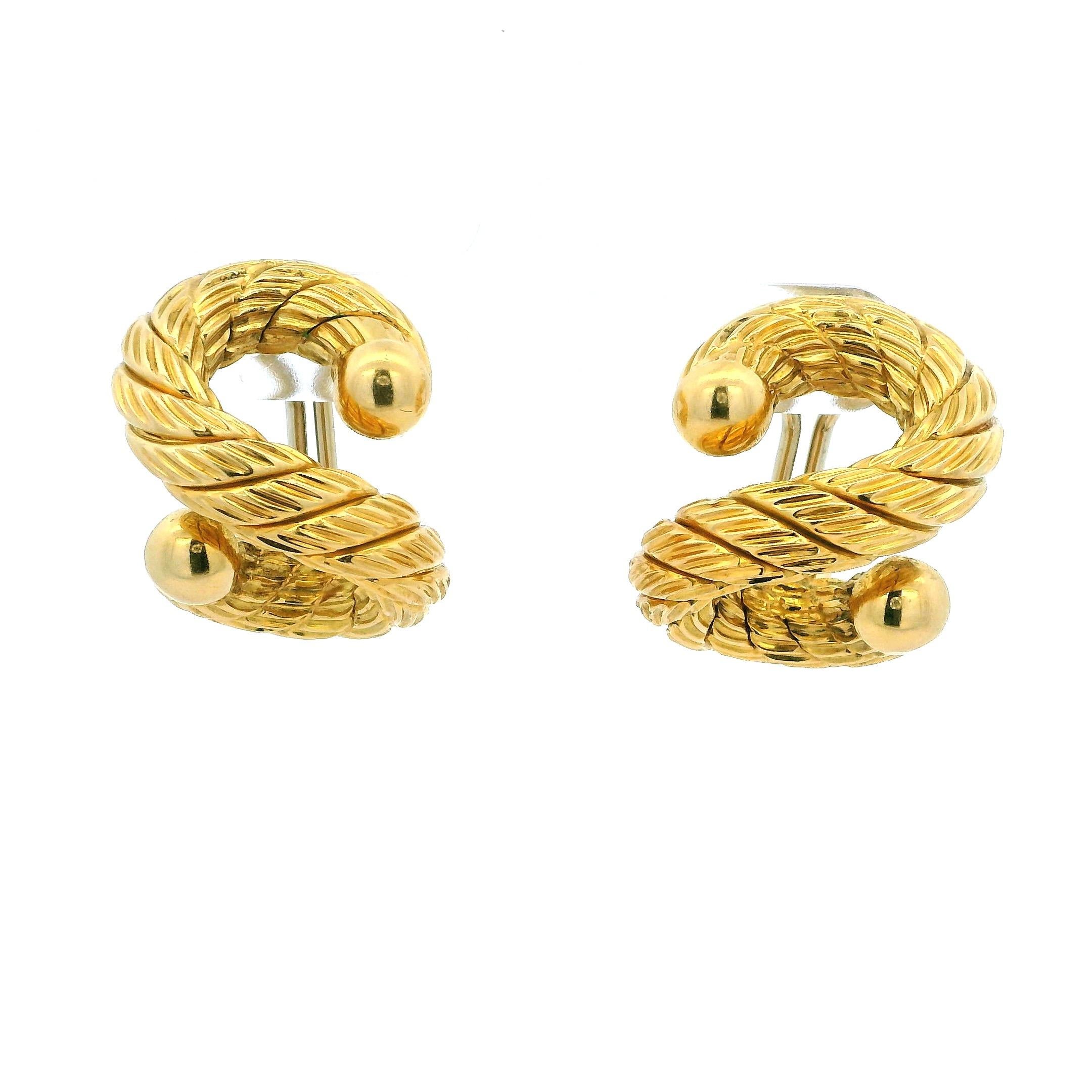 Estos elegantes aros abrazables de oro amarillo de 18 quilates son una clase magistral de diseño de joyería italiana, creados por Carlo Weingrill, uno de los orfebres más prestigiosos de Vicenza, Italia. Fundada en 1879, Weingrill se ha forjado una