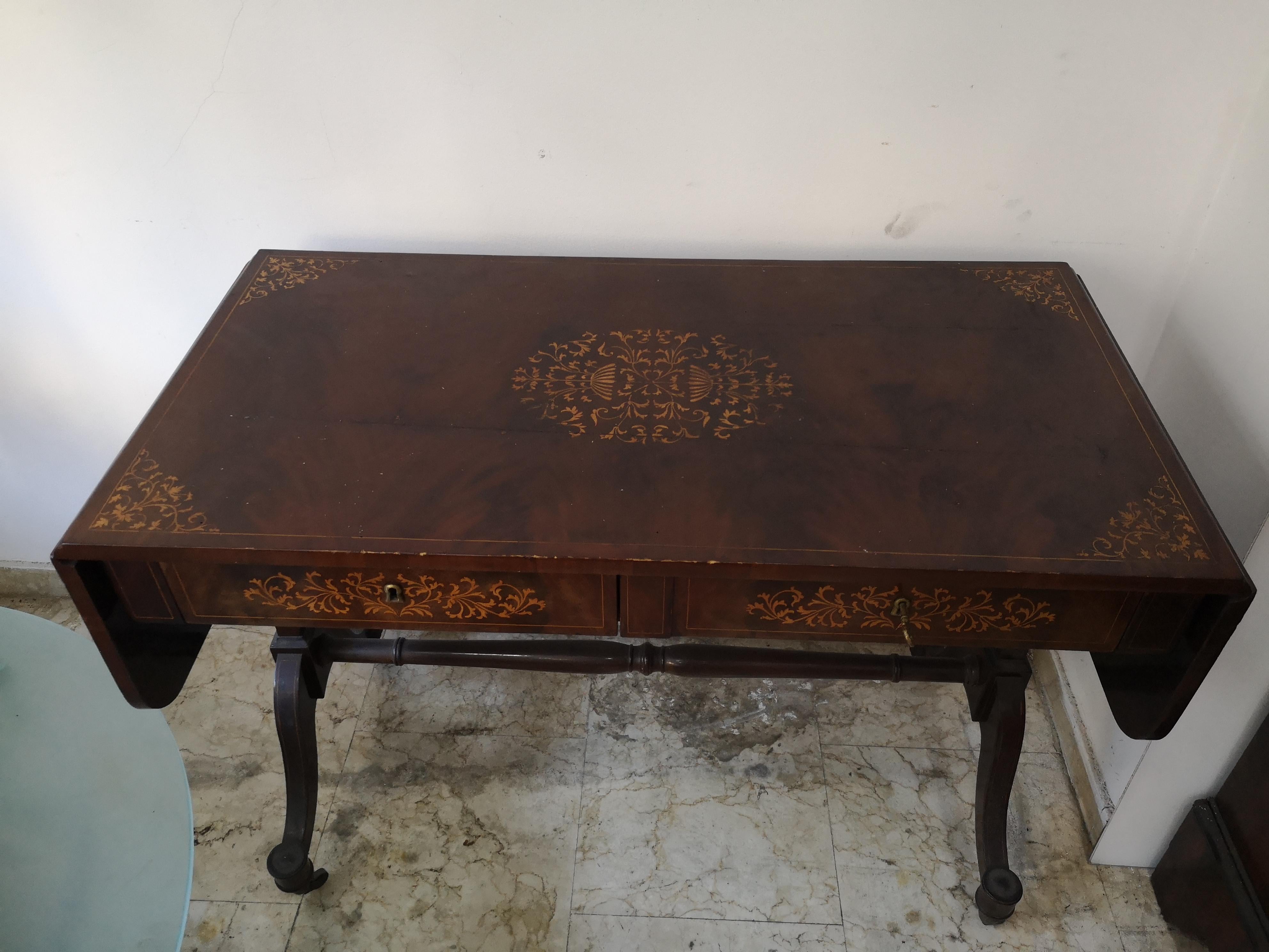 Scrittoio Carlo X metà 800 a bandelle in piuma di mogano con intarsi 
e due cassetti e con gambe arcuate e unite da traversa con 4 ruote.

Lo scrittoio misura:
Lunghezza da chiuso  cm  110
Lunghezza aperto        cm  165
Larghezza                   