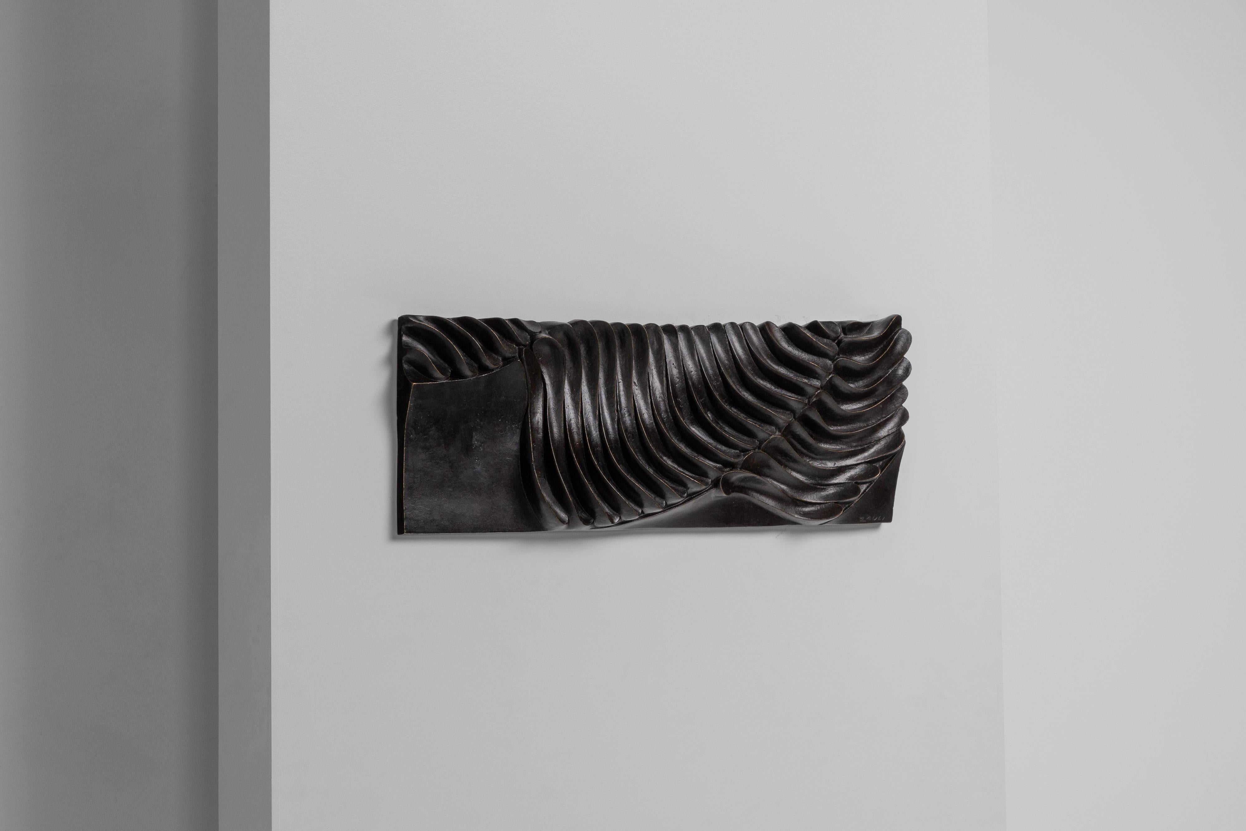 Stunning abstract wall sculpture beautifully handmade by Carlo Zauli in his Italian workshop during the 1960s. It's a substantial piece, expertly made from solid bronze. The organic shaped sculpture includes its original white painted wooden back