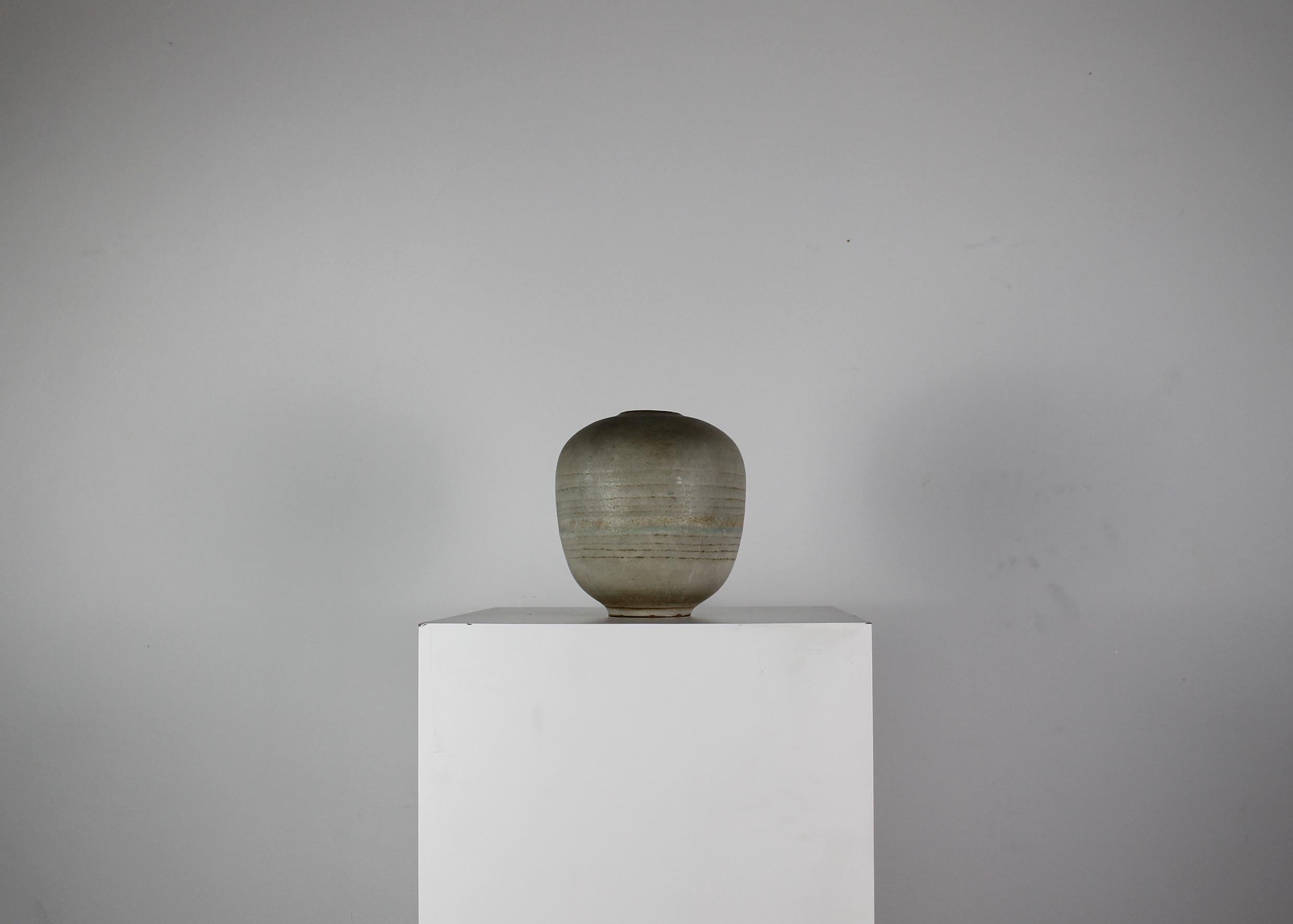 Rare round-shaped vase realized in a warm gray stoneware with band decorations, designed and manufactured by Carlo Zauli in 1960s. 

Signature engraved visible under the base.

After winning the main awards dedicated to ceramic art in the 1950s,