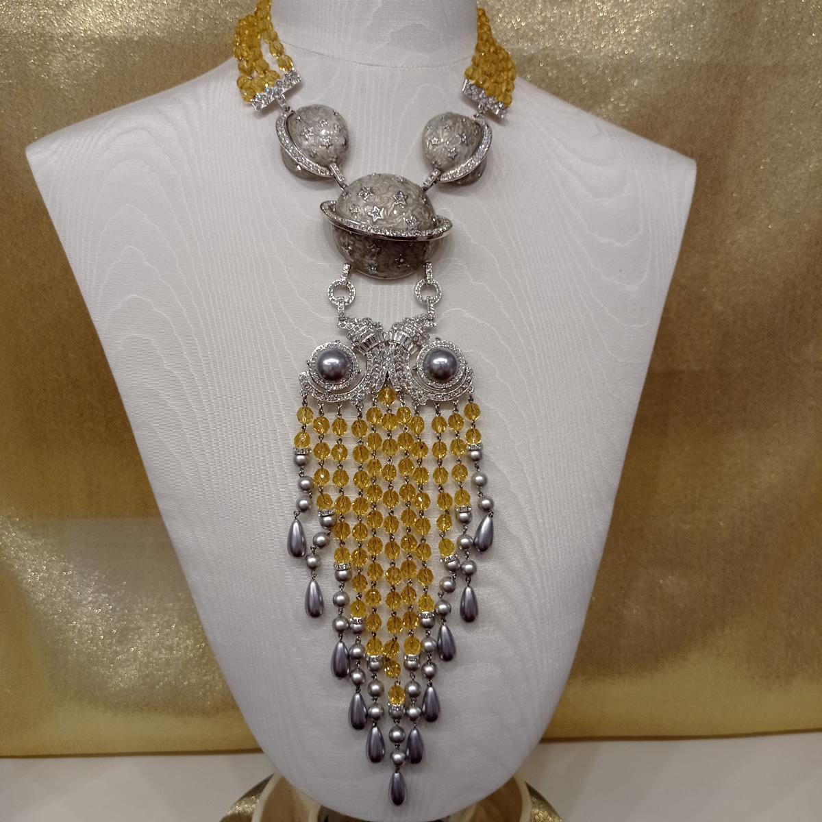 Fantastic masterpiece by Carlo Zini
One of the world greatest bijoux designers
Maxi necklace
Saturn theme
Grey elements and faux pearls
Swarovski crystals
Faceted citrine colored crystals
Non allergenic rhodium
100% Artisanal work made in