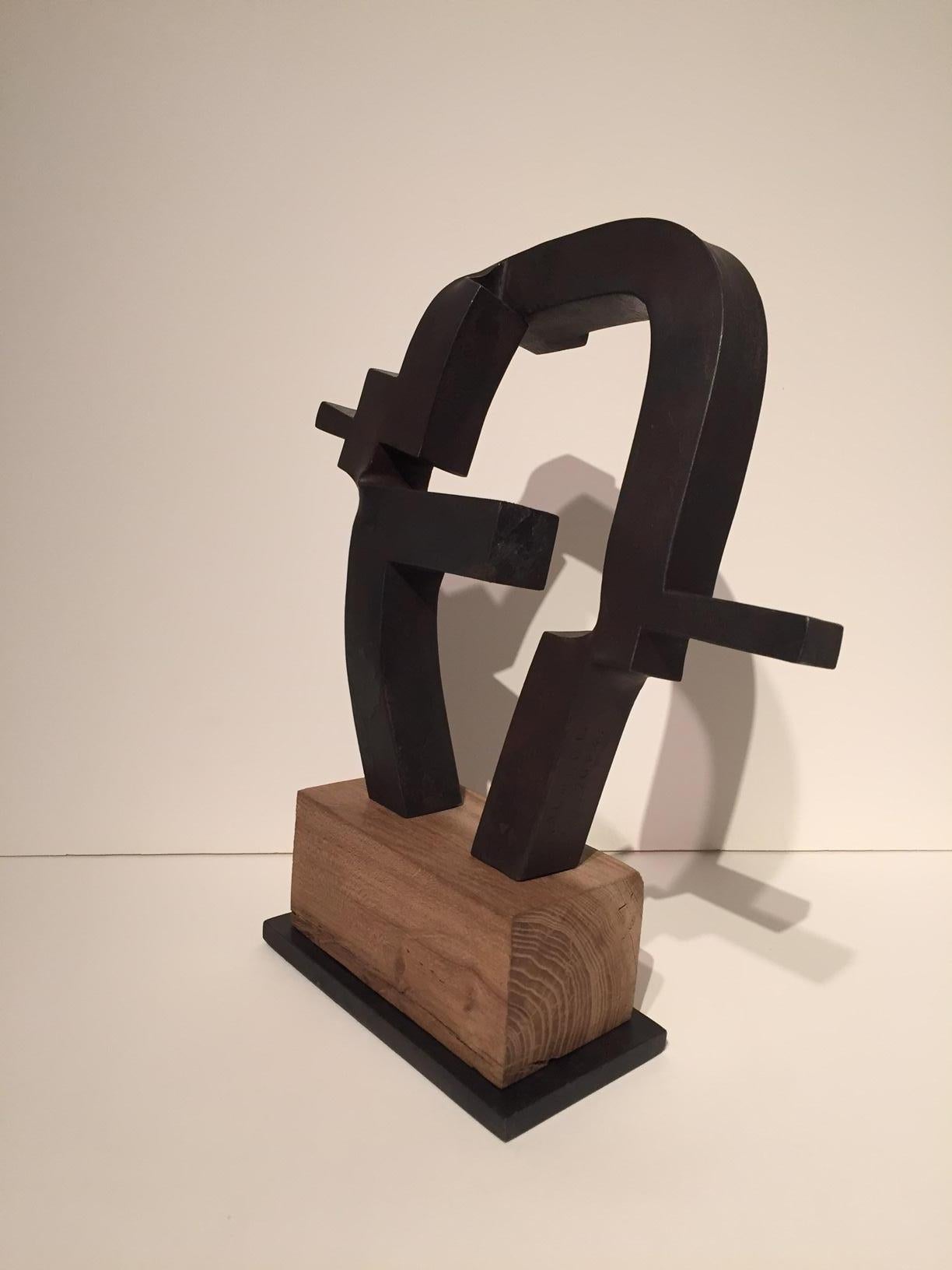 This is a 3 dimensional sculpture by Spanish abstract expressionist, Carlos Albert in dark gray forged steel on a natural light poplar wood base. 

Carlos Albert is a graduate of the School of Fine Arts at the Universidad de Complutense in Madrid,