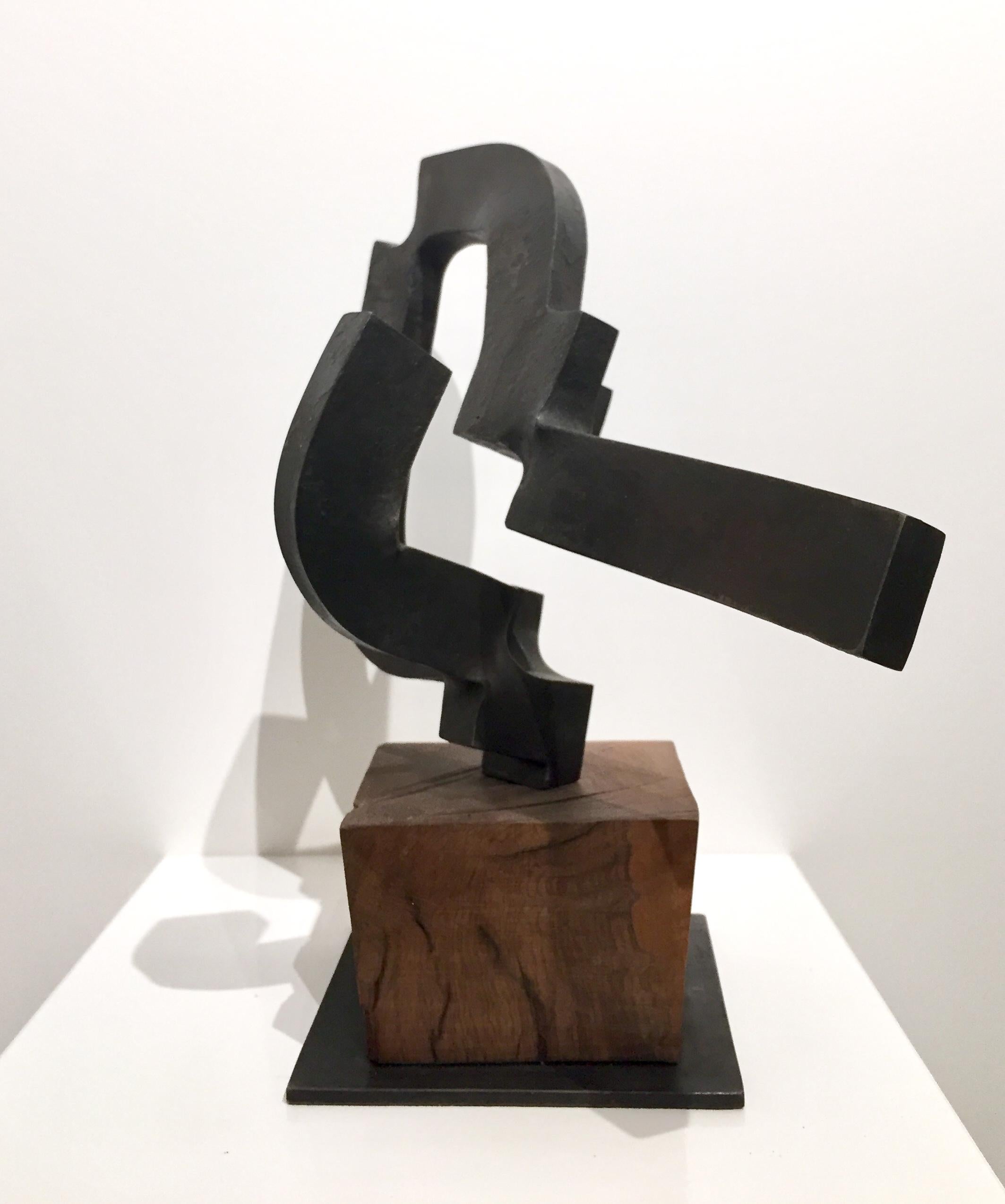 This is a 3 dimensional sculpture by Spanish abstract expressionist, Carlos Albert in dark gray forged steel on a natural light poplar wood base. 

Carlos Albert is a graduate of the School of Fine Arts at the Universidad de Complutense in Madrid,