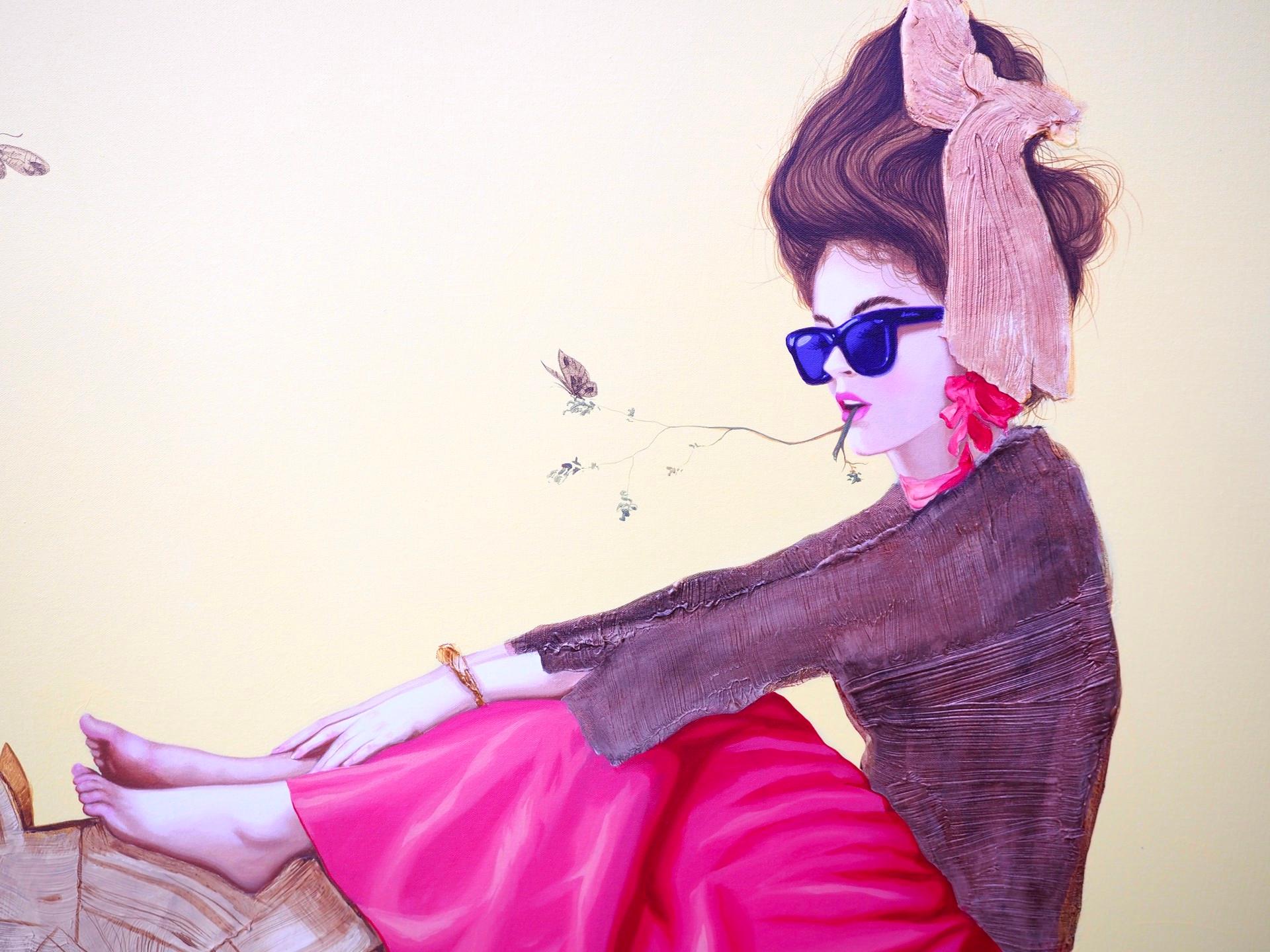 Le cavalier représente une femme portant une longue jupe rose et des lunettes de soleil bleu foncé. Le modèle est assis sur un âne en bois, ses pieds nus posés sur la tête de l'animal. Un papillon se pose sur un morceau d'herbe qui part des lèvres
