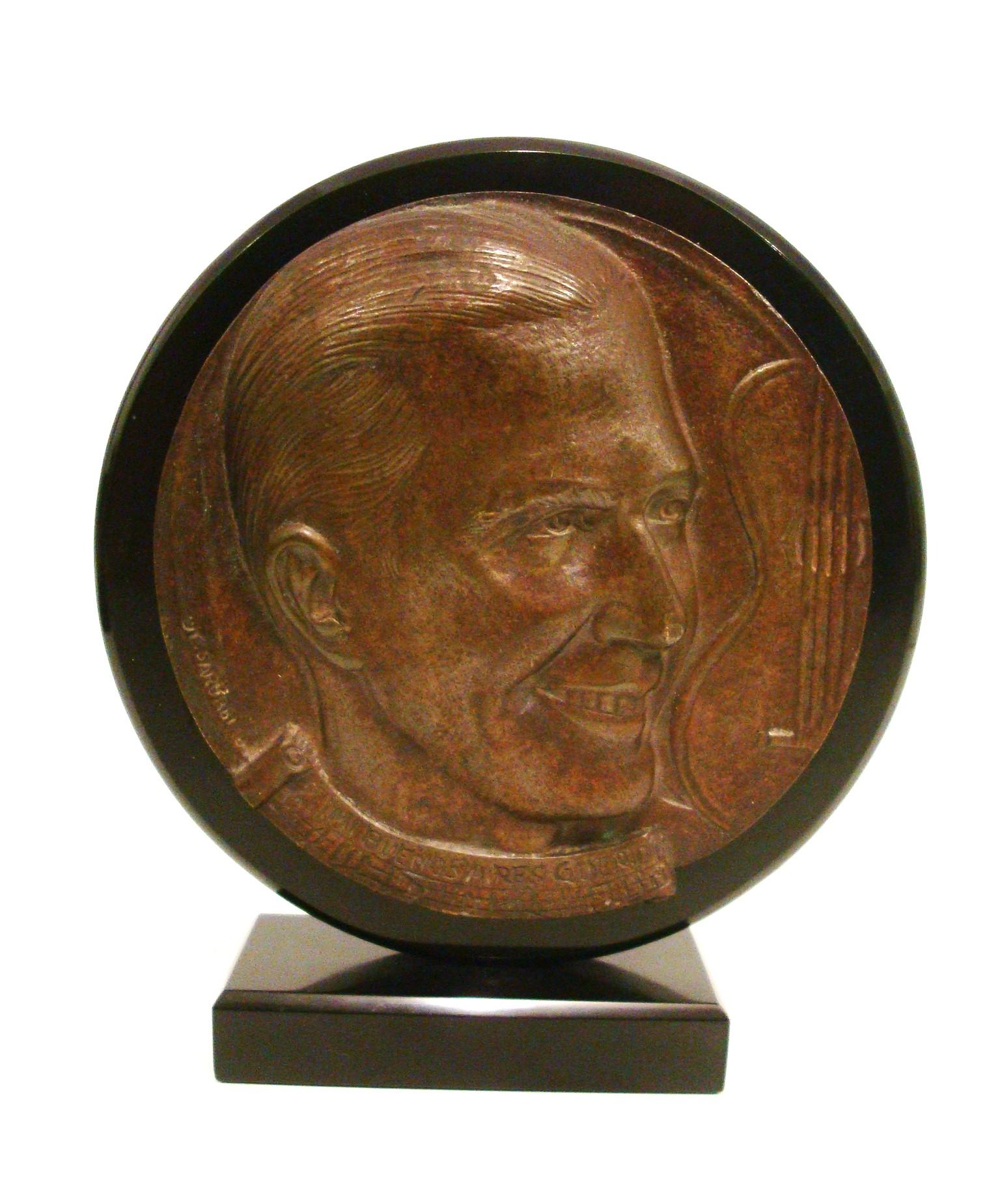 Ritratto/scultura di Carlos Gardel Tango in bronzo e marmo.
La firma è difficile da capire.

Charles Gardel (nato Charles Romuald Gardès; 11 dicembre 1890 - 24 giugno 1935) è stato un cantante, cantautore, compositore e attore argentino di origine