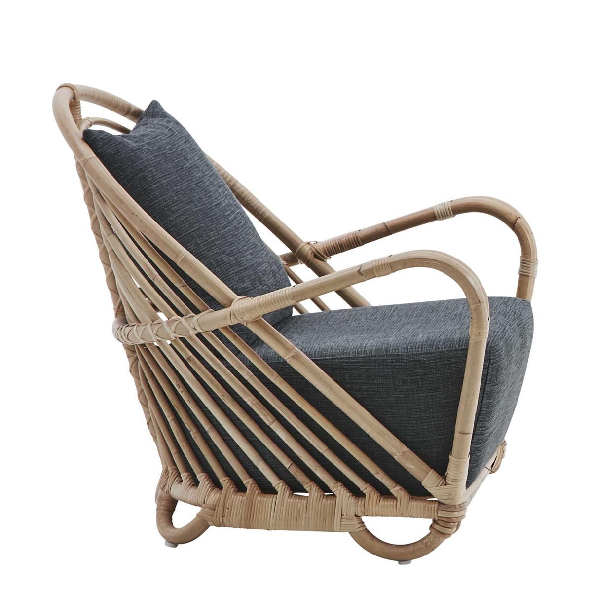 Armchair Carlotta all handmade
in Manau rattan. Seat and backrest cushion
covered with deep taupe fabric.