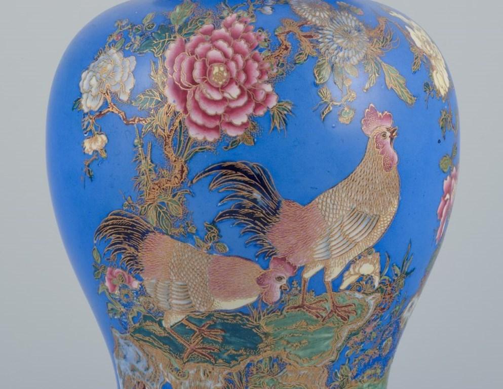 Carlton Ware, England. Large and rare lidded vase in faience.
Decorated in cloisonné technique.
Oriental style with a motif of two roosters in a floral landscape.
1920s/1930s.
Marked.
Model number: 2309.
Perfect condition.
Dimensions: Height 36.0 cm
