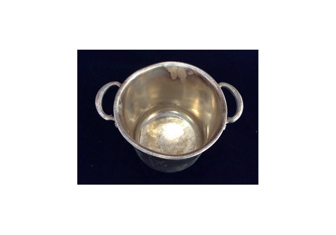 A heavy aged Hollywood Regency Era Hotel silver bucket form Champagne Cooler dating from the 1940s-1950s and acquired from New York City’s famed Carlyle Hotel. In very good all original condition including overall aging and tarnish
with many age